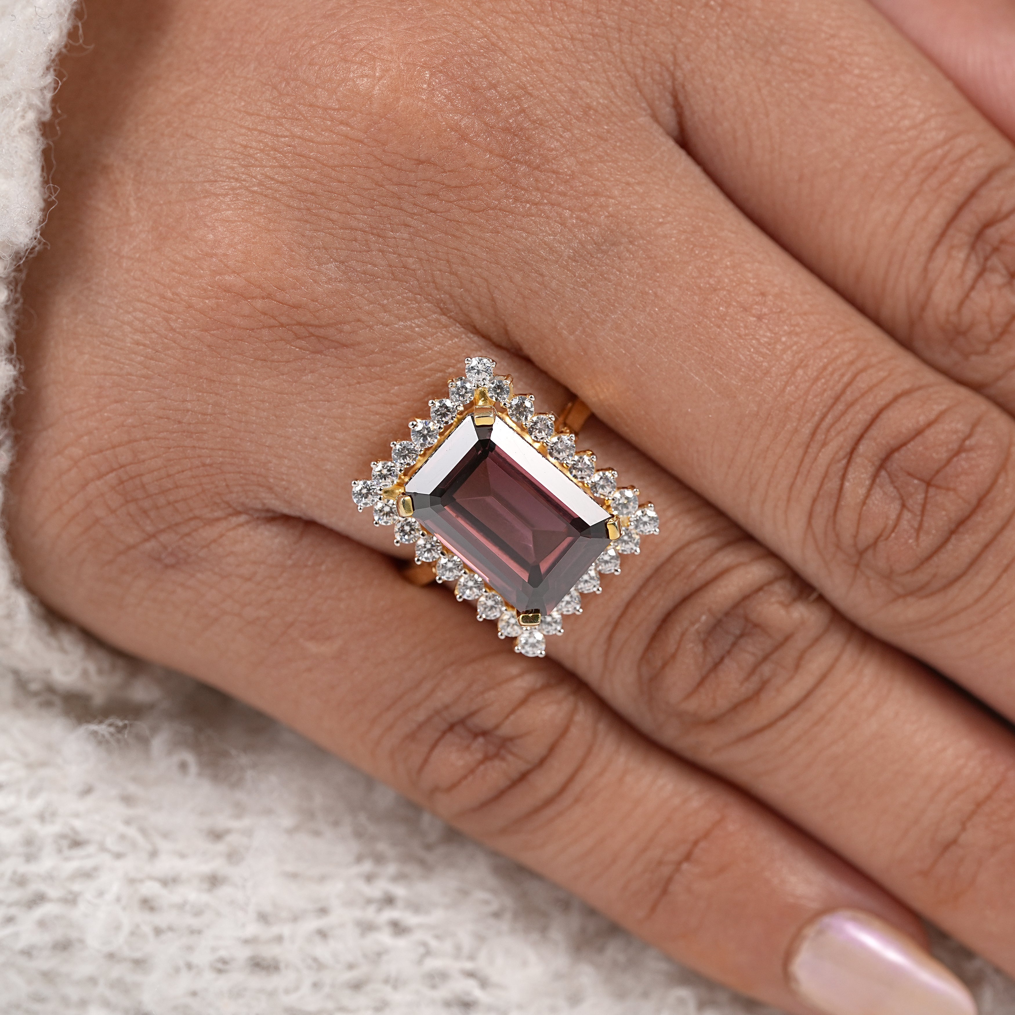 Minimalist yellow gold garnet ring with emerald cut stone and diamond halo