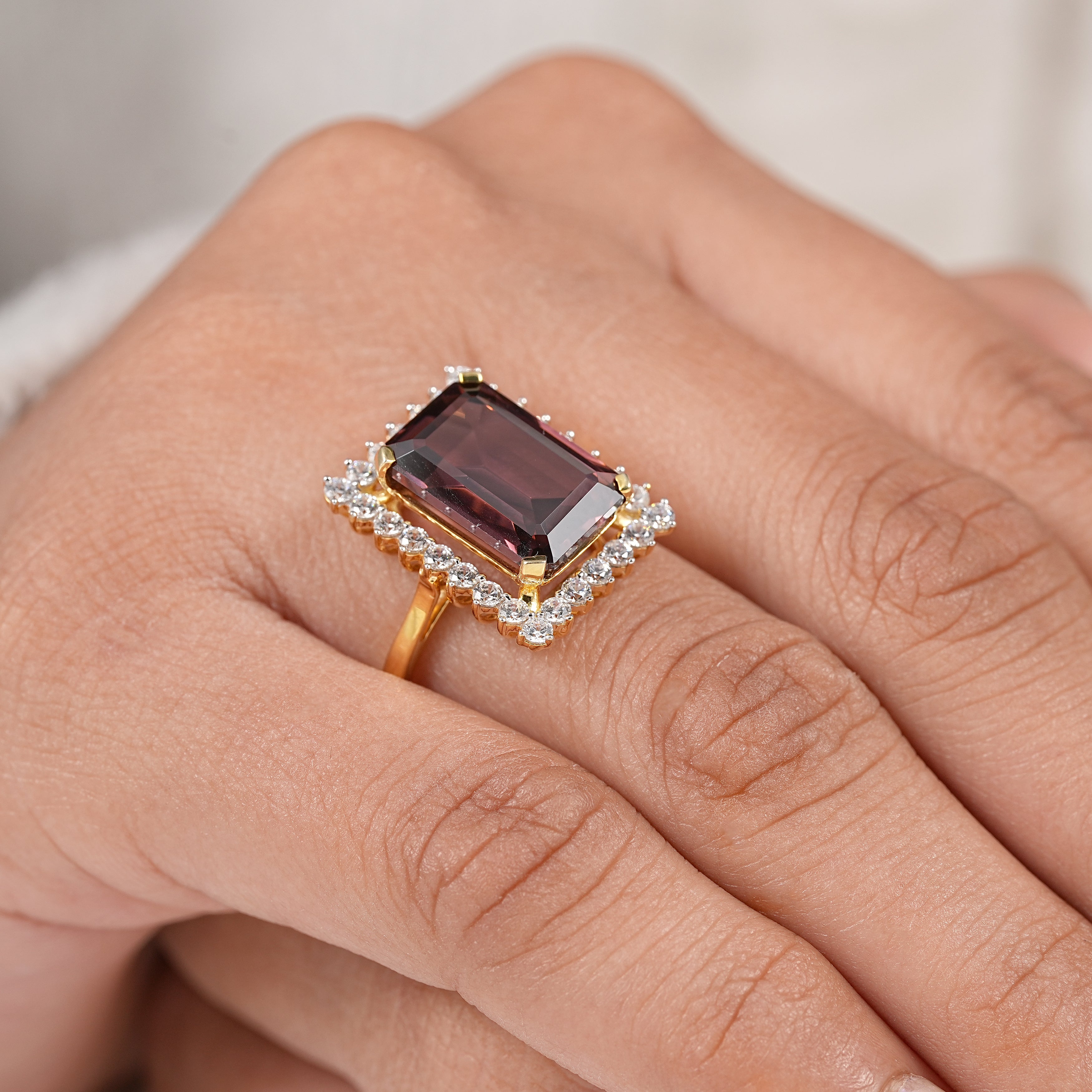 Unique wine red garnet halo ring with elegant emerald cut gemstone setting