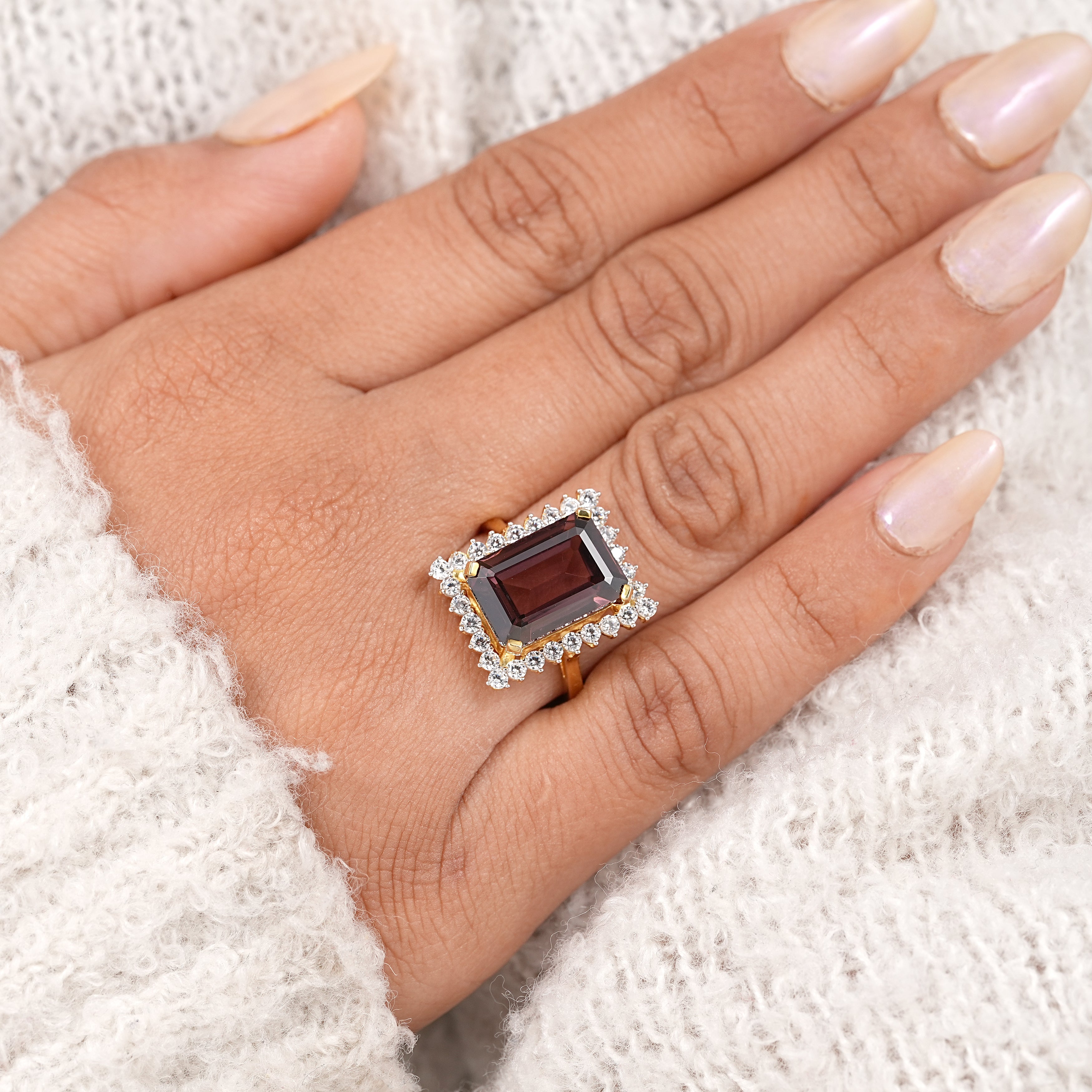 Art deco style garnet halo ring with emerald cut center and gold band