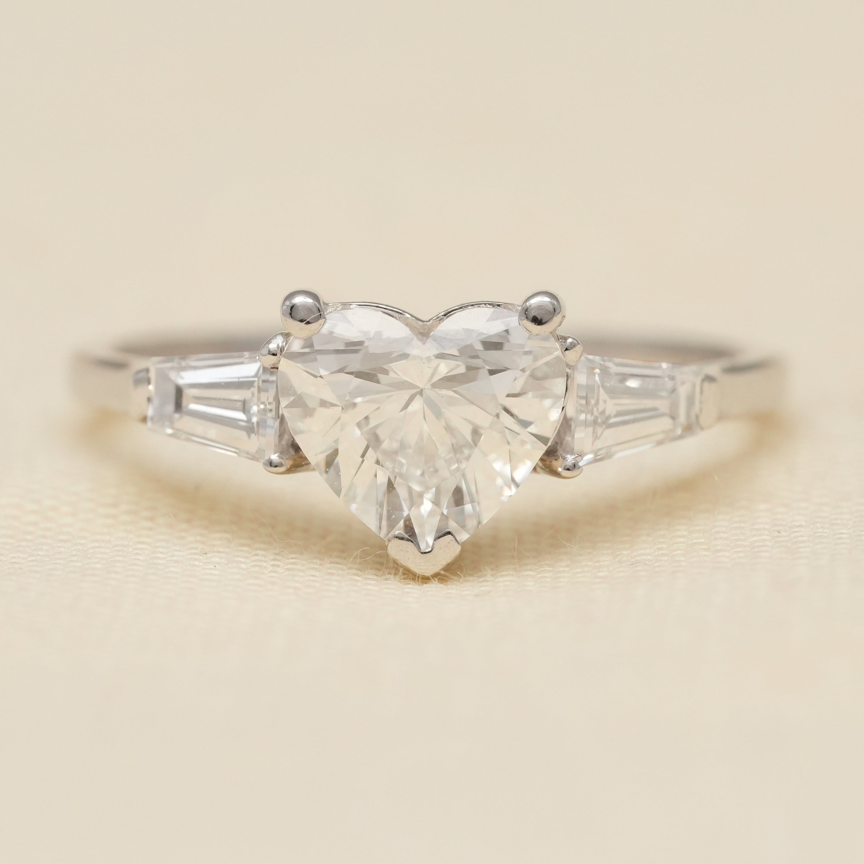 Heart cut engagement ring featuring lab grown diamond with baguette side stones