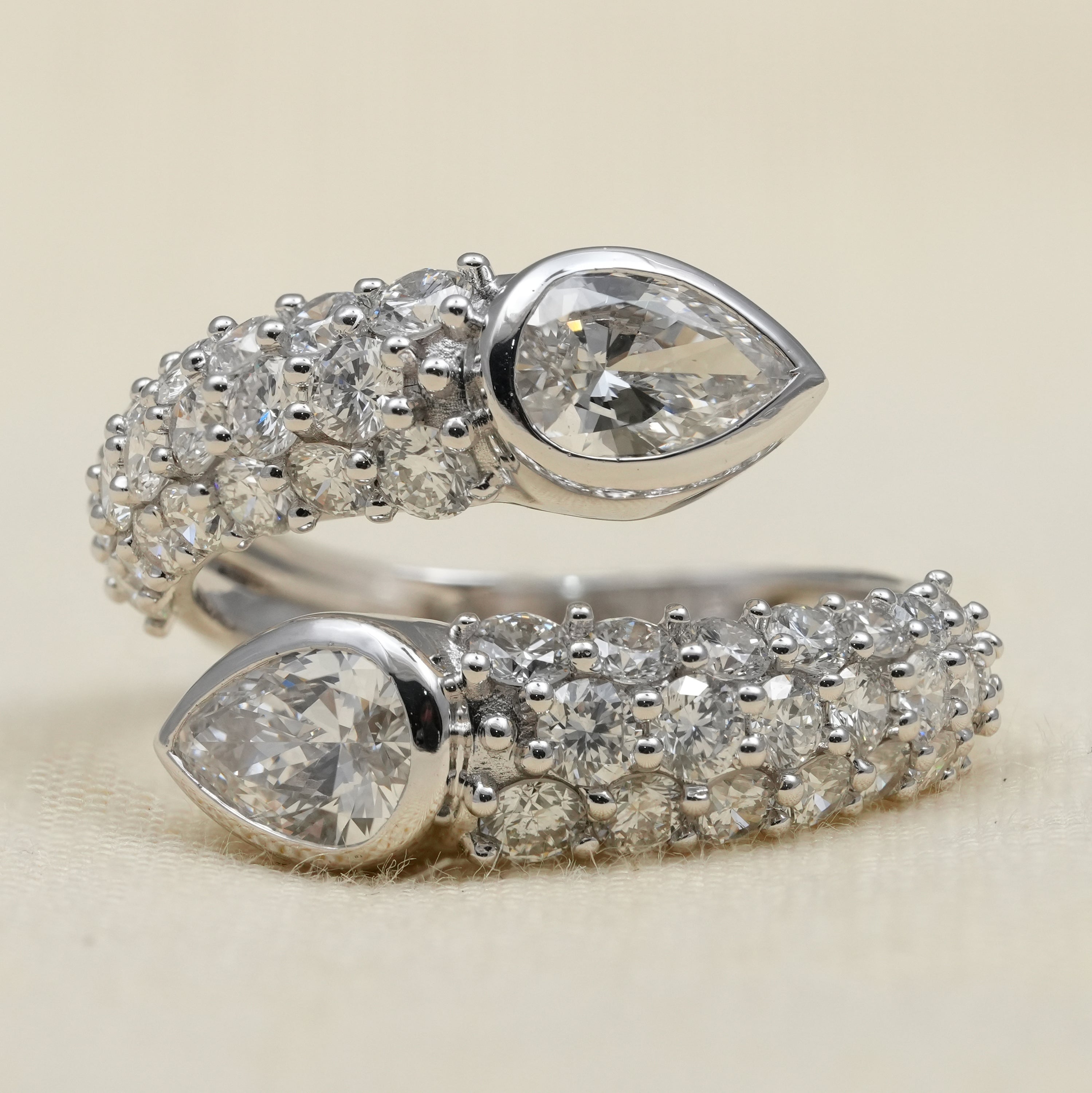 Open bypass ring featuring pear lab grown diamonds with pavé accents