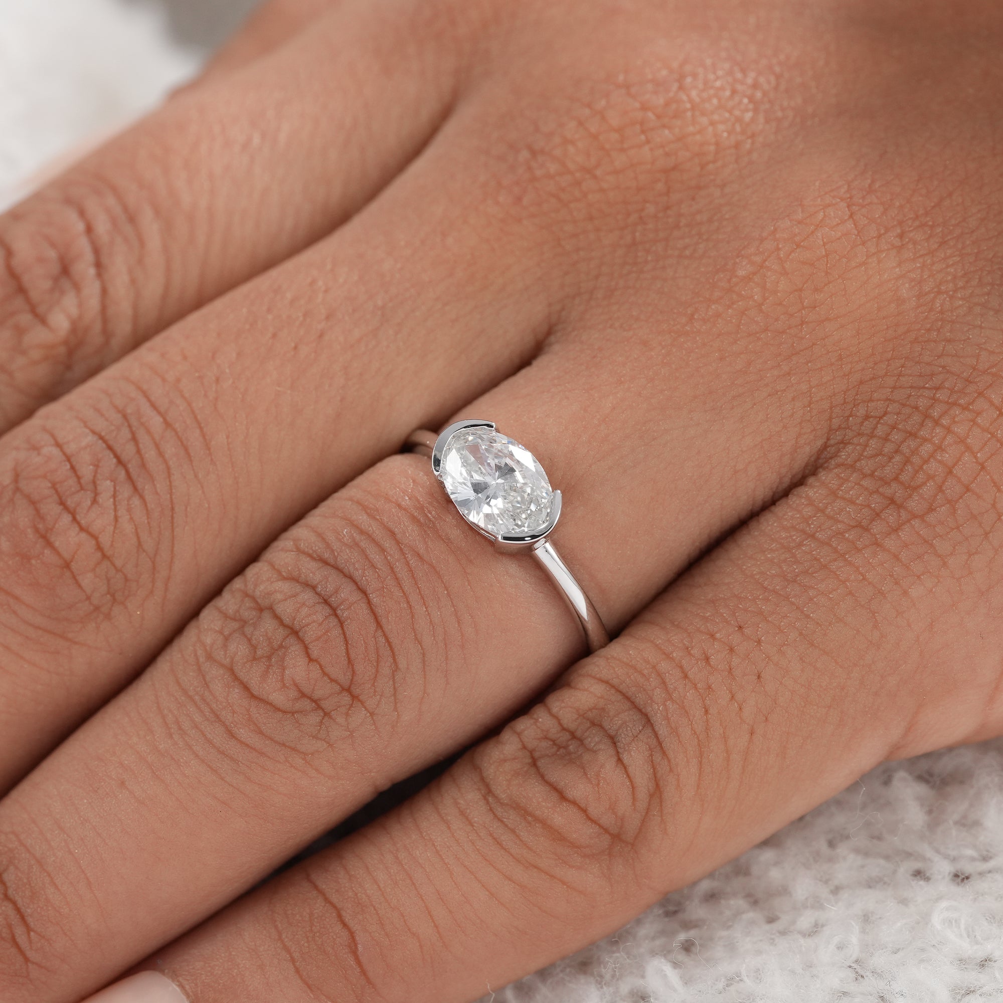 Horizontal oval diamond ring with sleek half bezel setting
