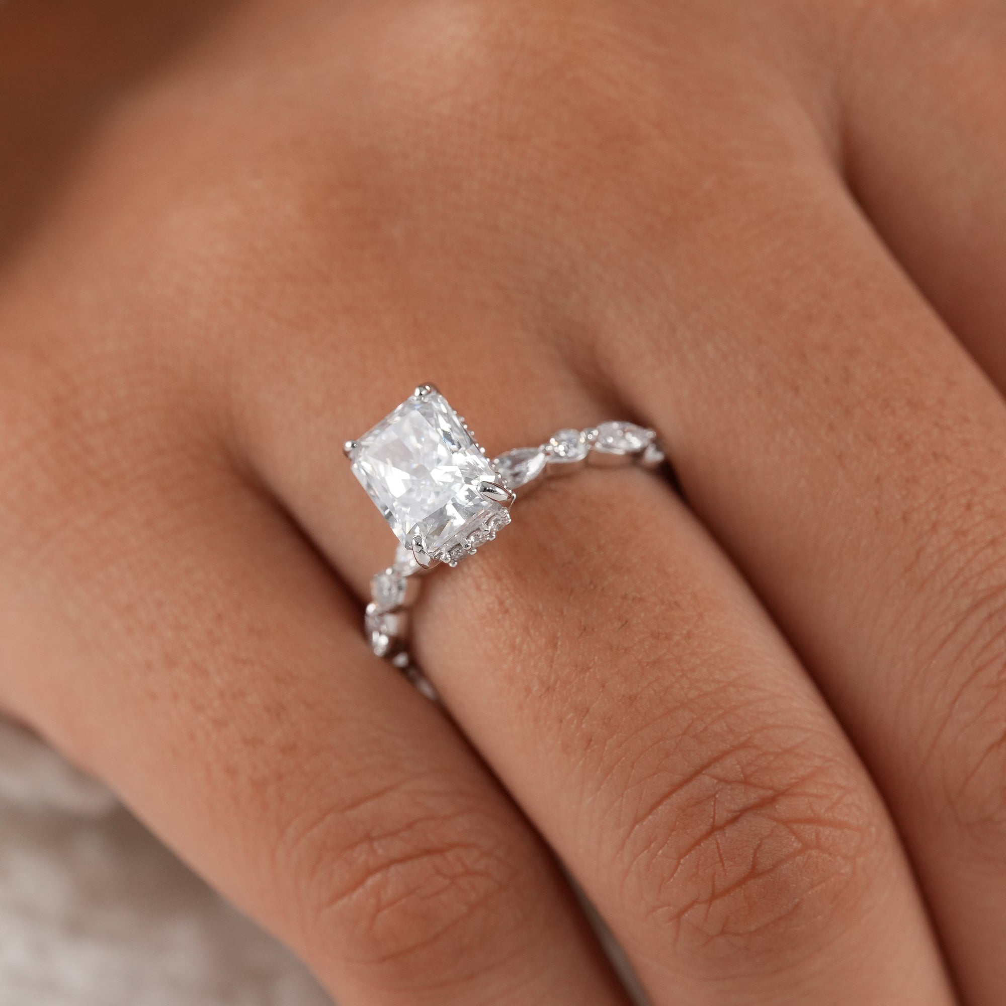 Modern radiant engagement ring with diamond accent band.