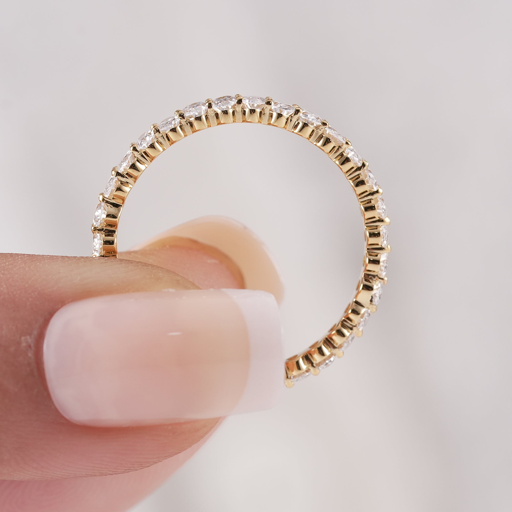 Sparkling oval cut diamond wedding ring in yellow gold.