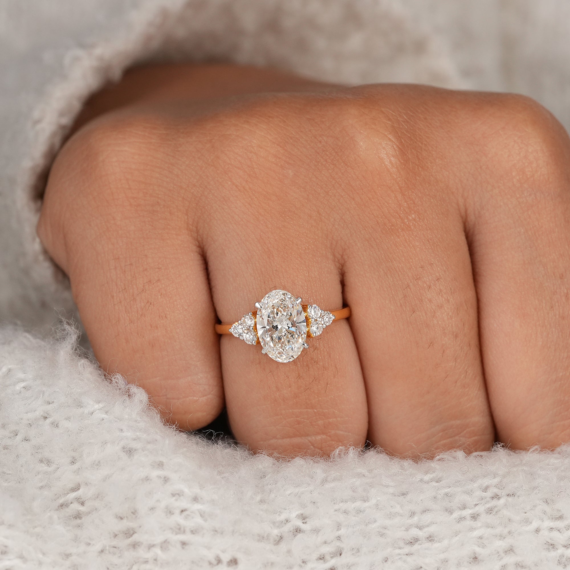 Oval wedding ring featuring floral round accent diamonds