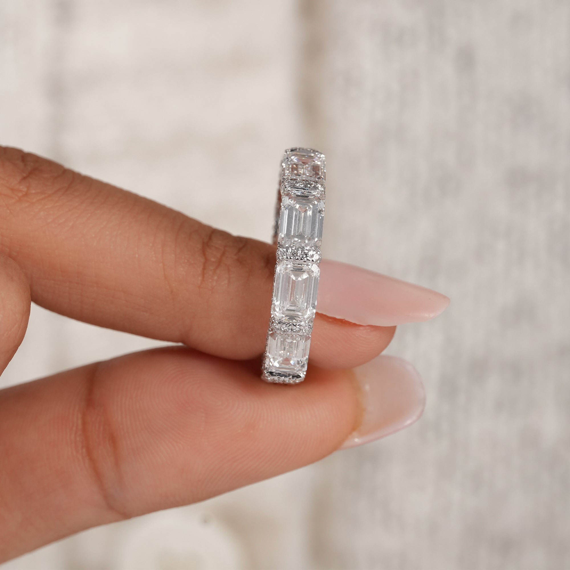 Women's emerald eternity band with sparkling pavé accents.