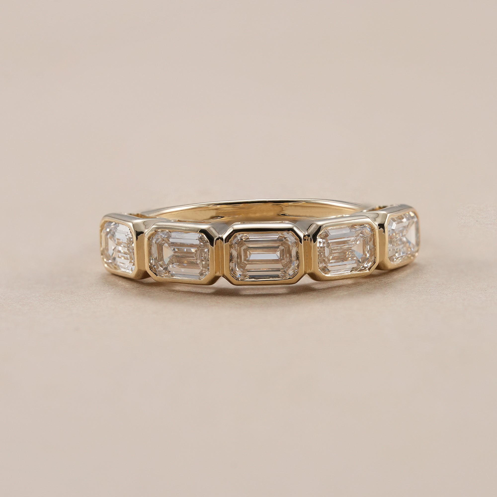 Emerald eternity ring with five bezel set lab grown diamonds.