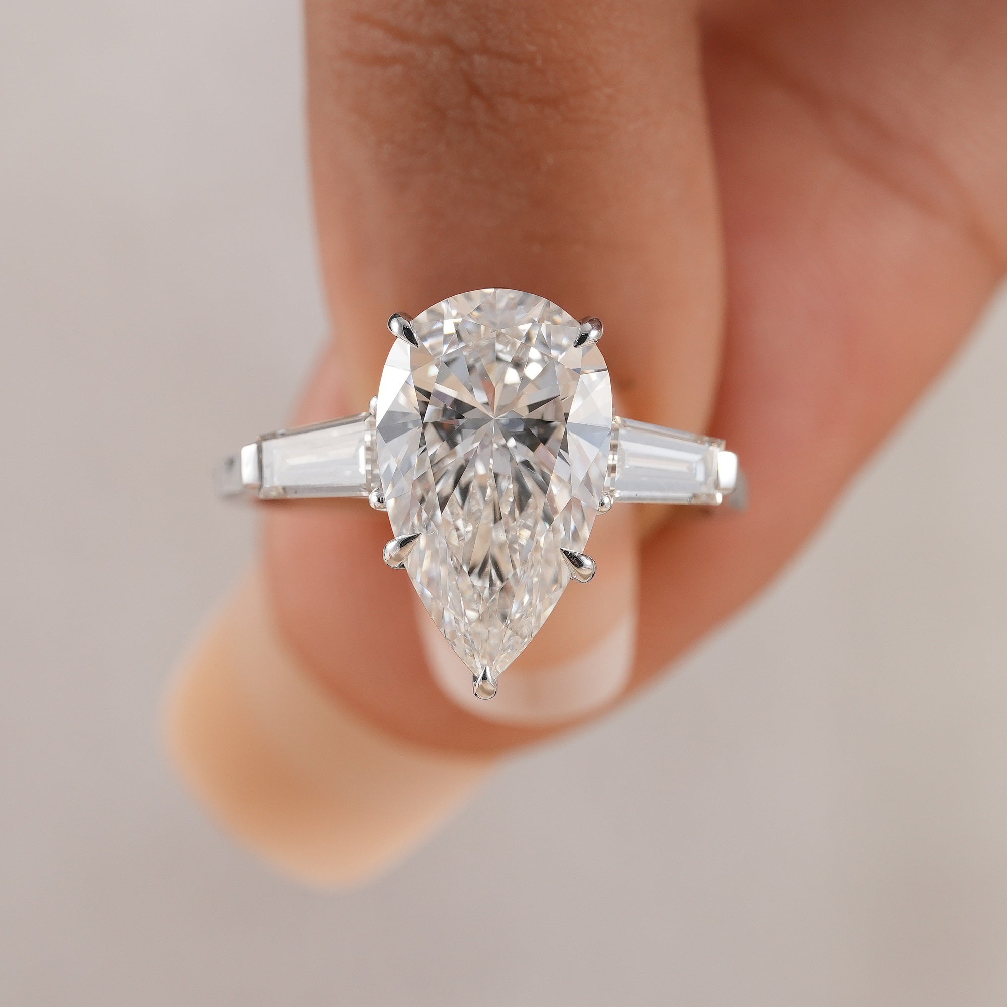 Three stone lab grown diamond ring with pear center stone