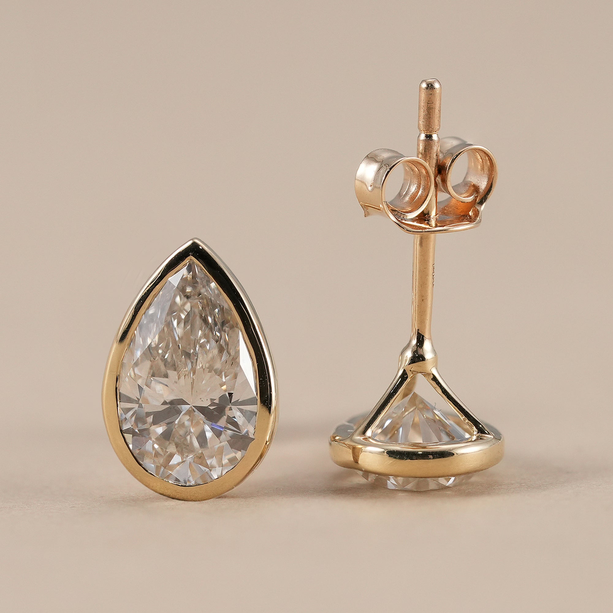 Elegant pear solitaire bezel earrings in solid gold
