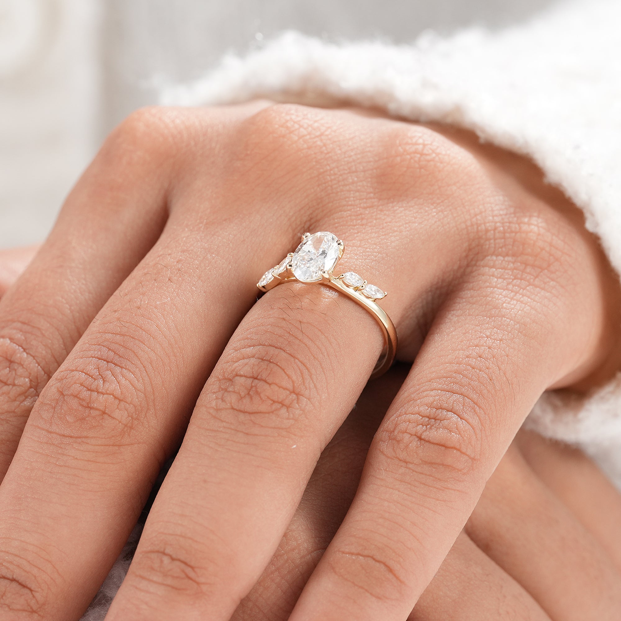 Oval engagement ring with marquise accent band in solid gold.