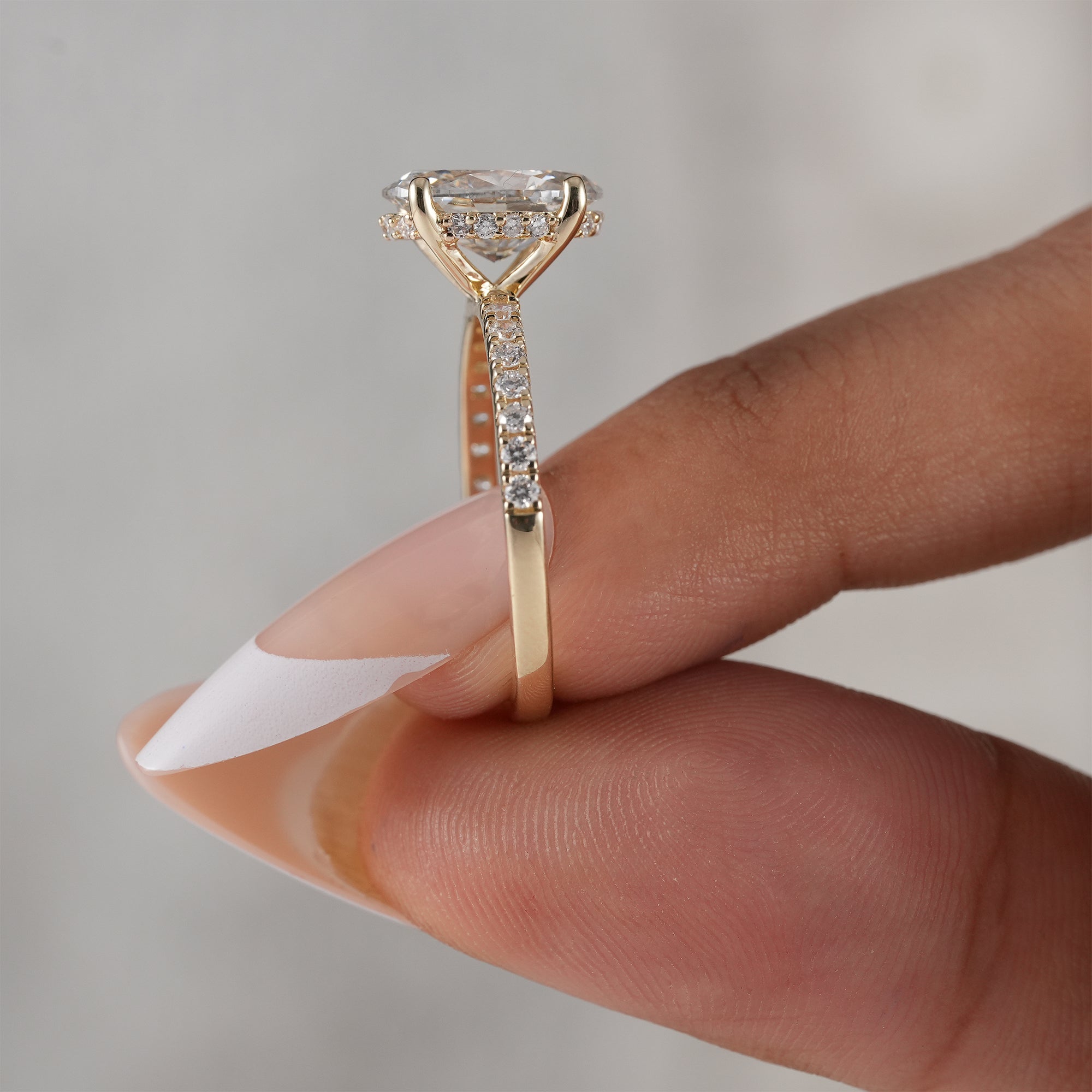 Four-prong oval lab diamond ring with hidden halo.