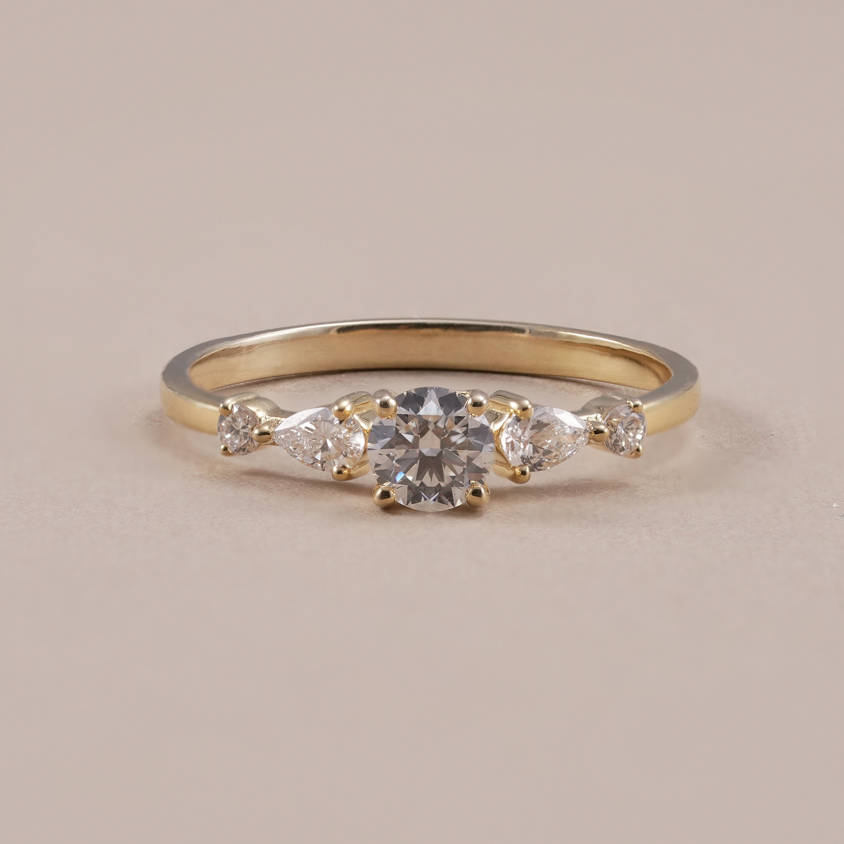 Five stone lab grown diamond ring with round center stone and pear accents