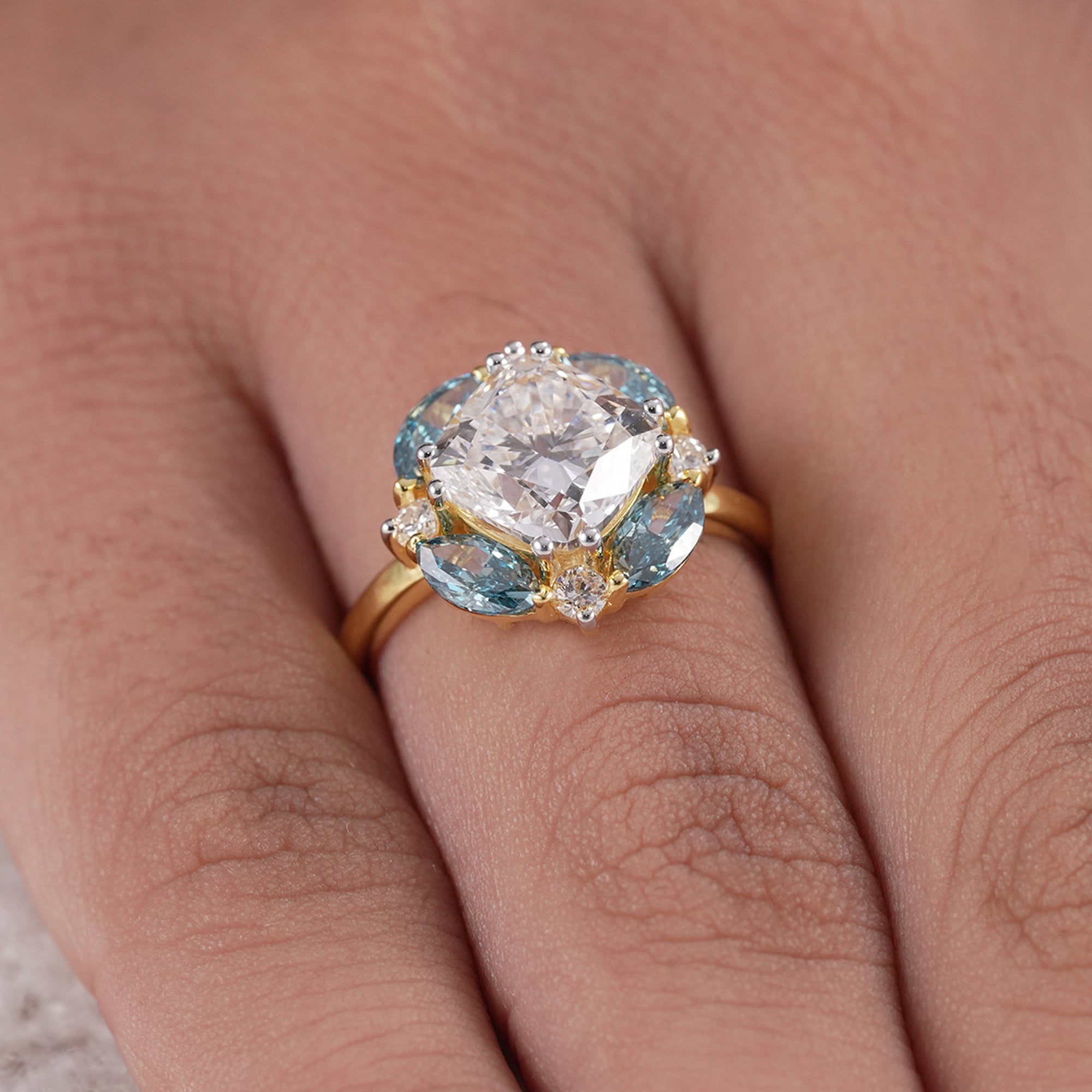 Elegant floral halo engagement ring with blue diamonds
