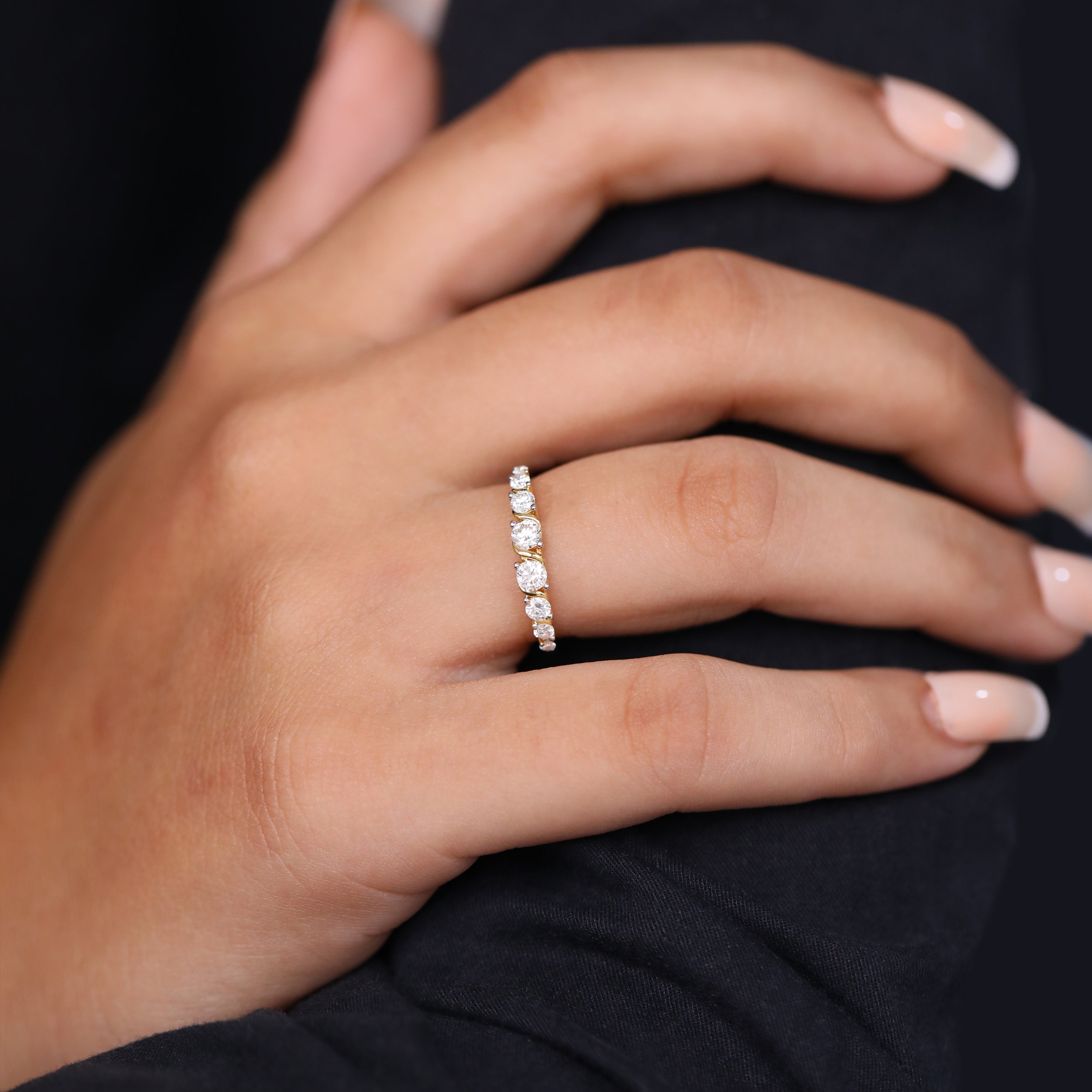 Fine gold ring with brilliant round cut diamonds placed in a flowing twist design.