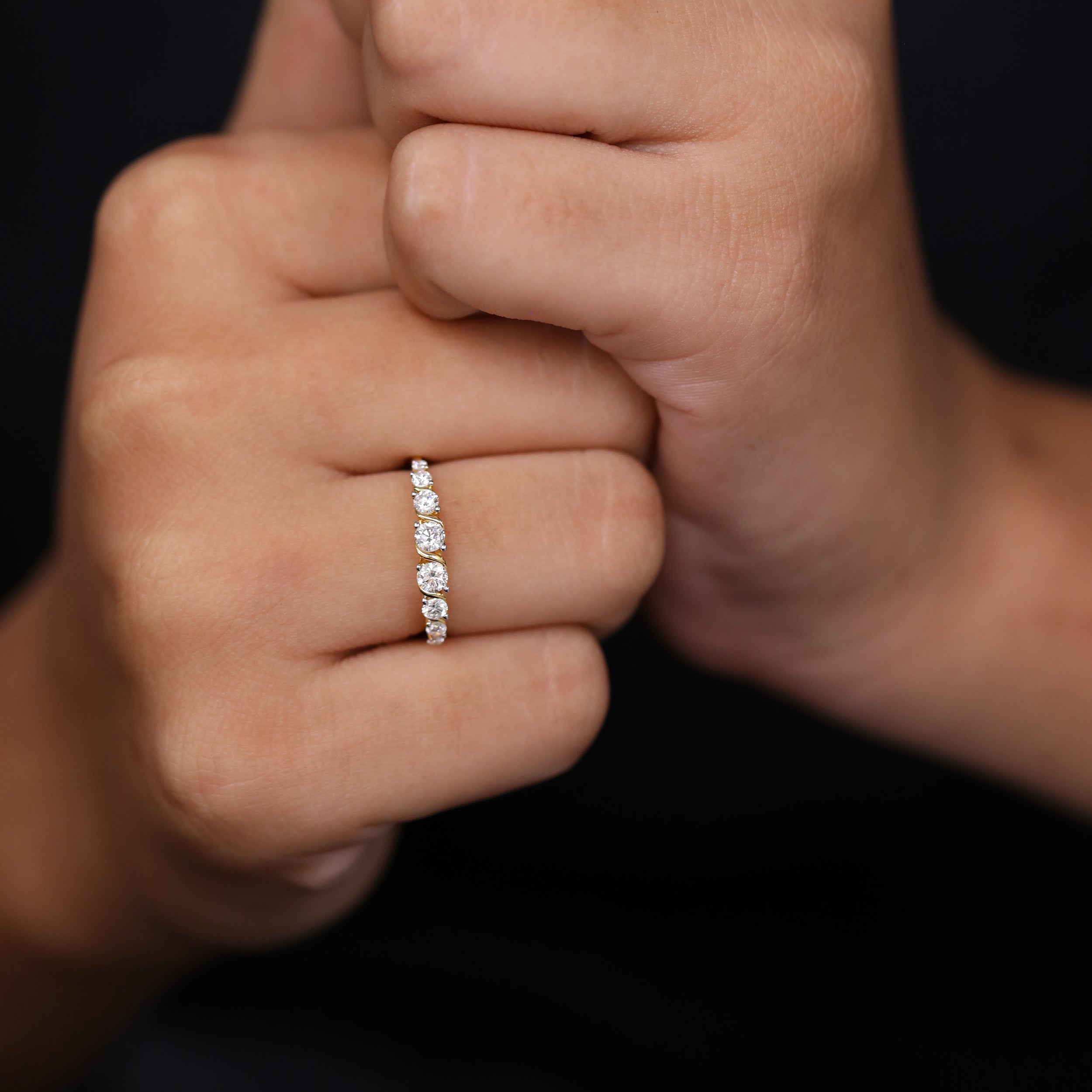 Luxurious gold diamond band accented with multiple round stones set in a sculpted swirl-inspired pattern.
