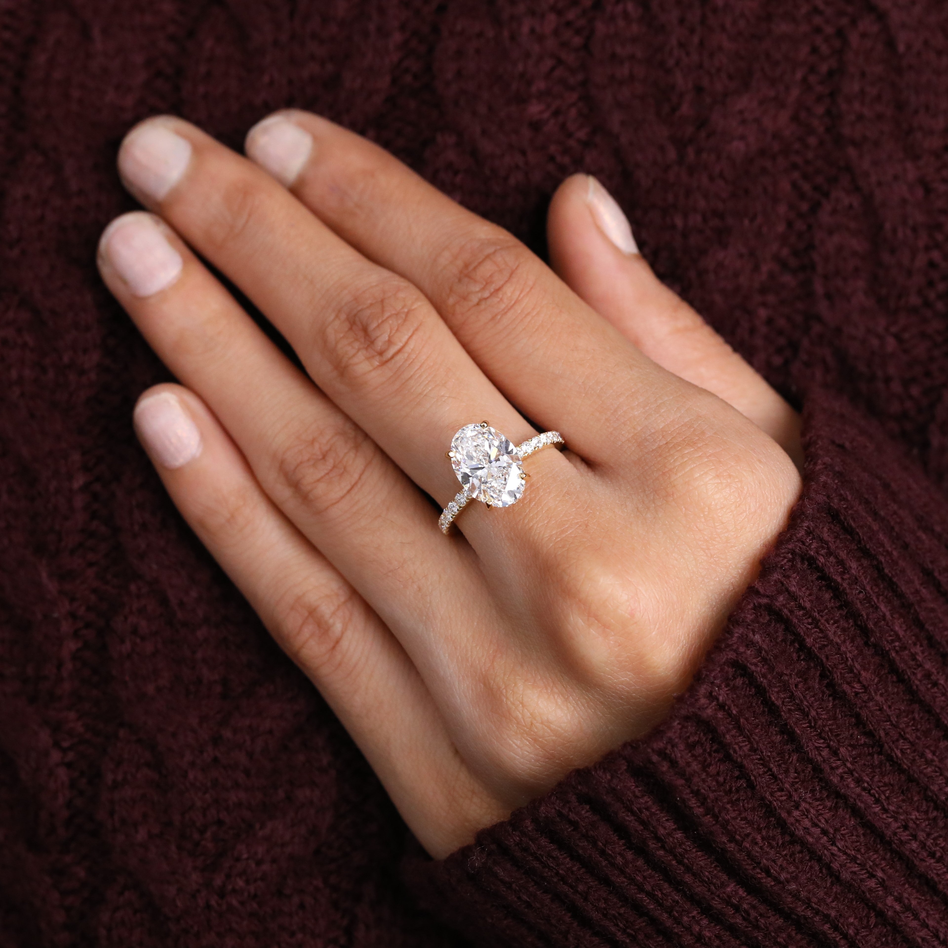 Modern oval solitaire ring with delicate pavé details on the band.