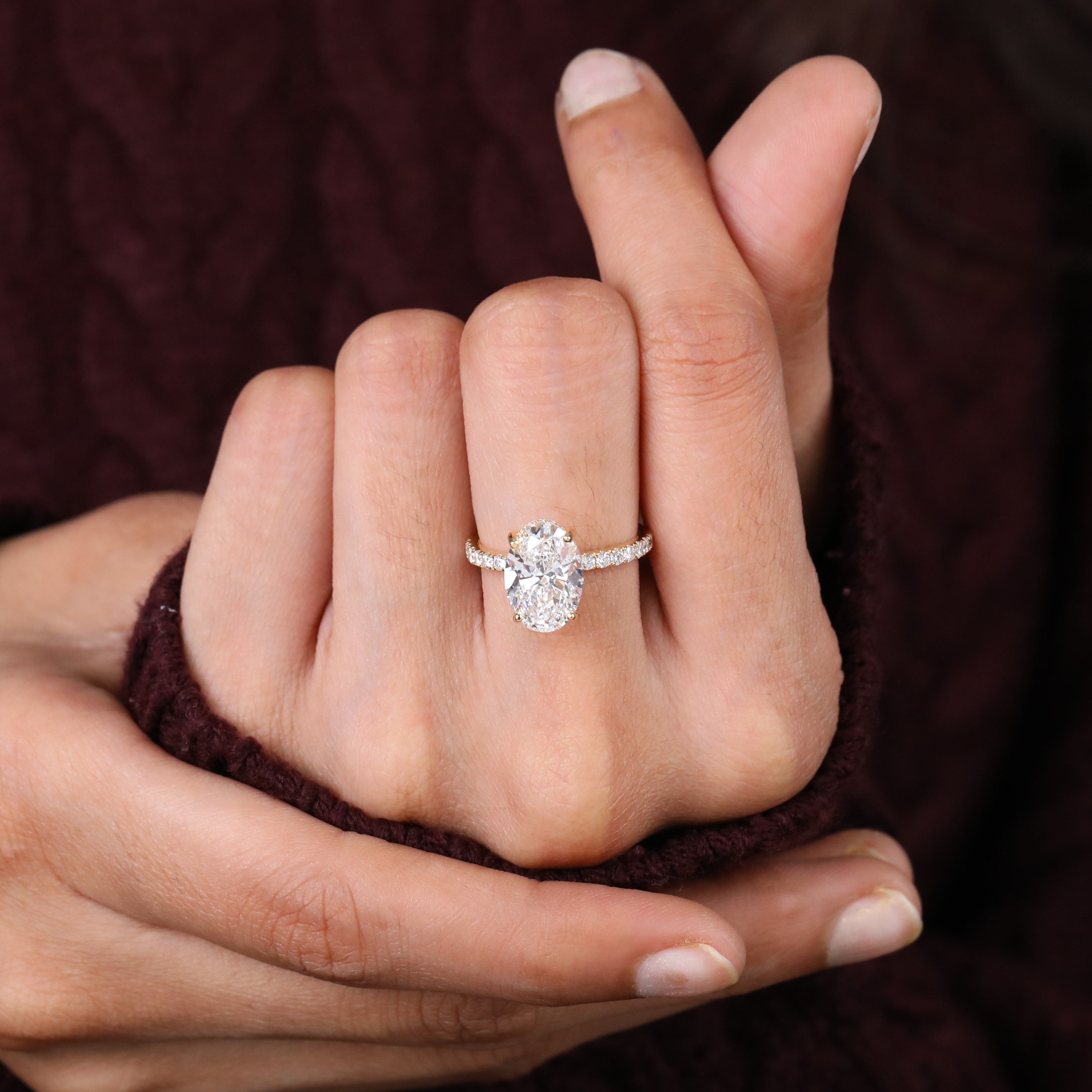 Oval stone engagement ring with a slim gold band and pavé sparkle