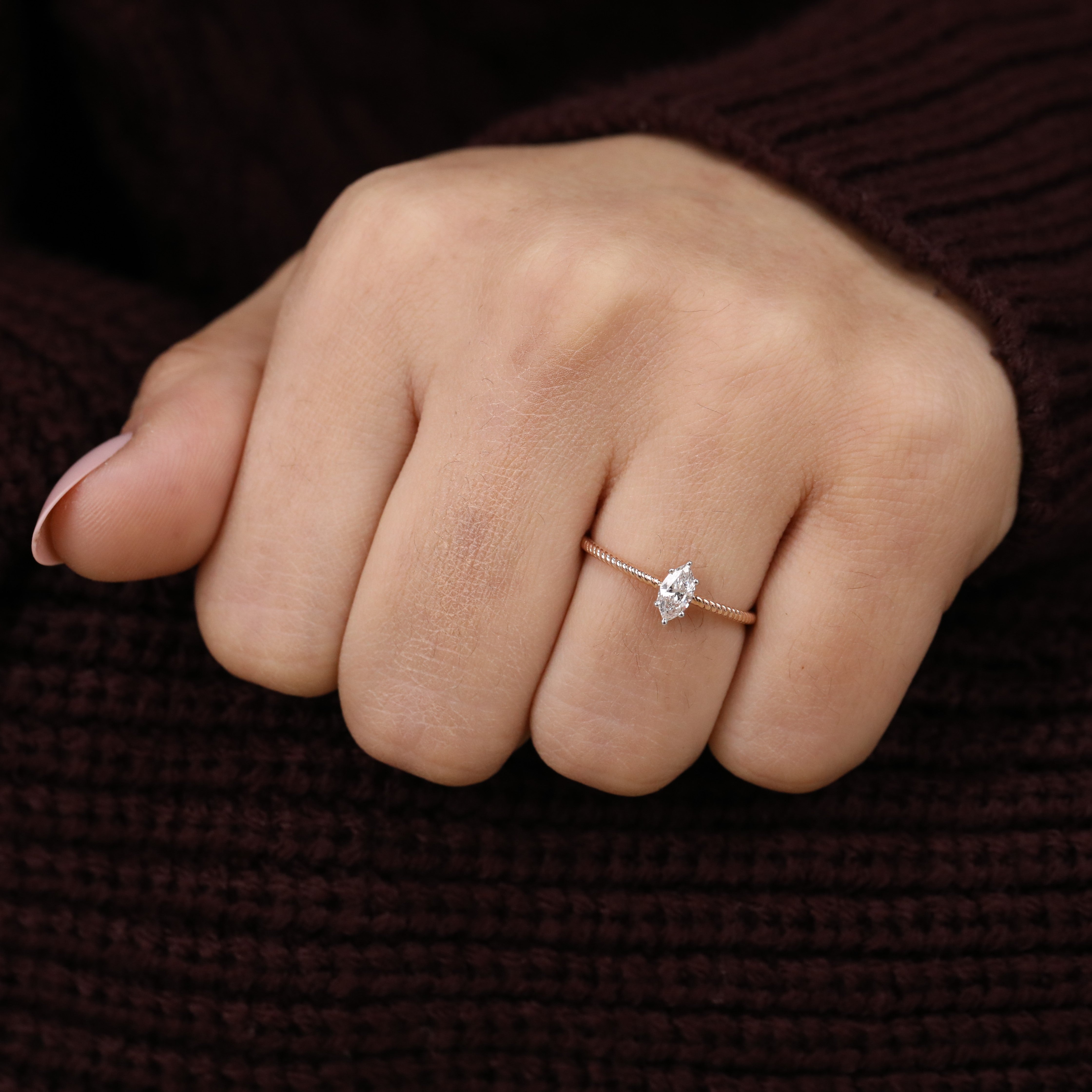 Minimalist twisted band ring showcasing a marquise cut lab grown diamond