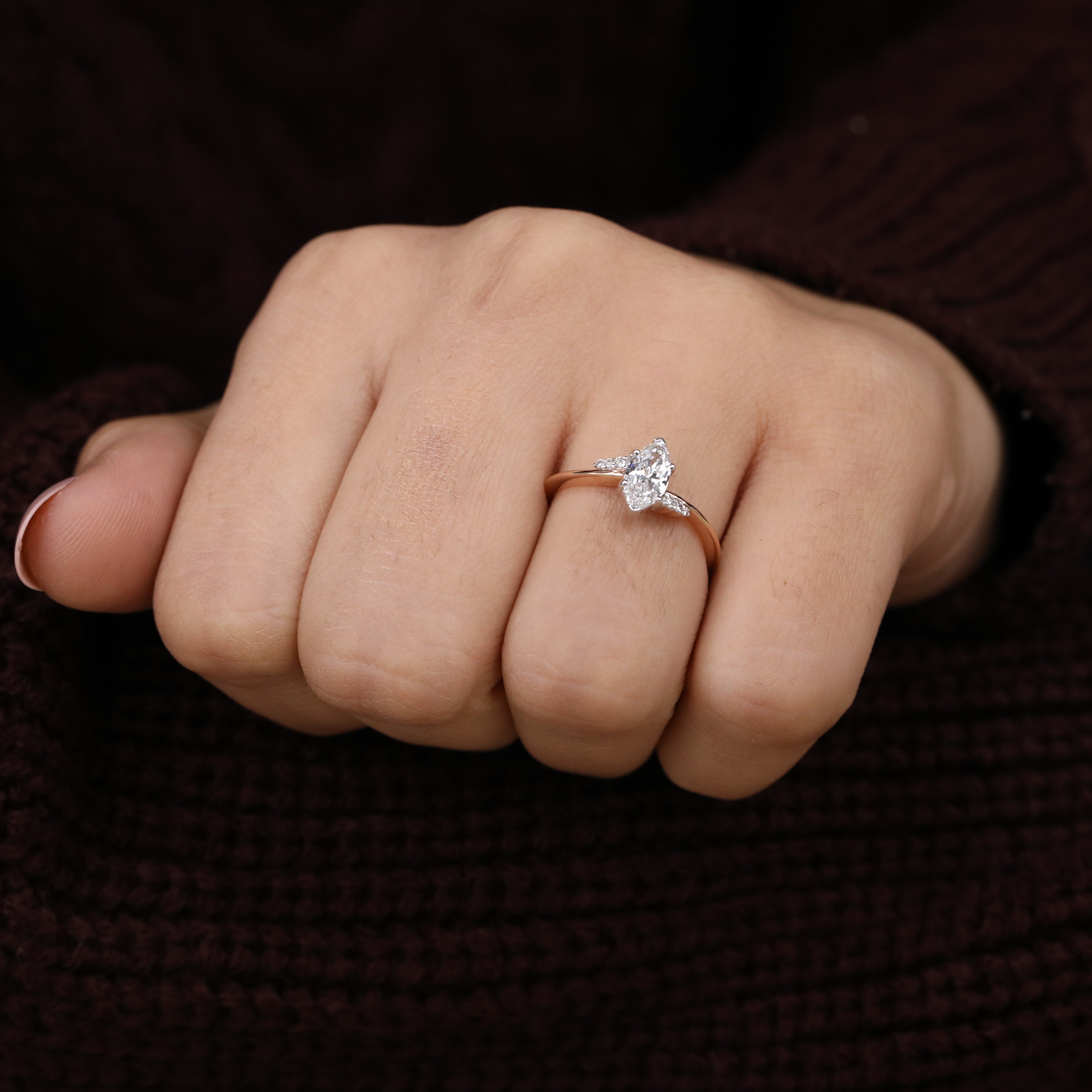 Stylish ring showcasing a marquise lab grown diamond with small side stones