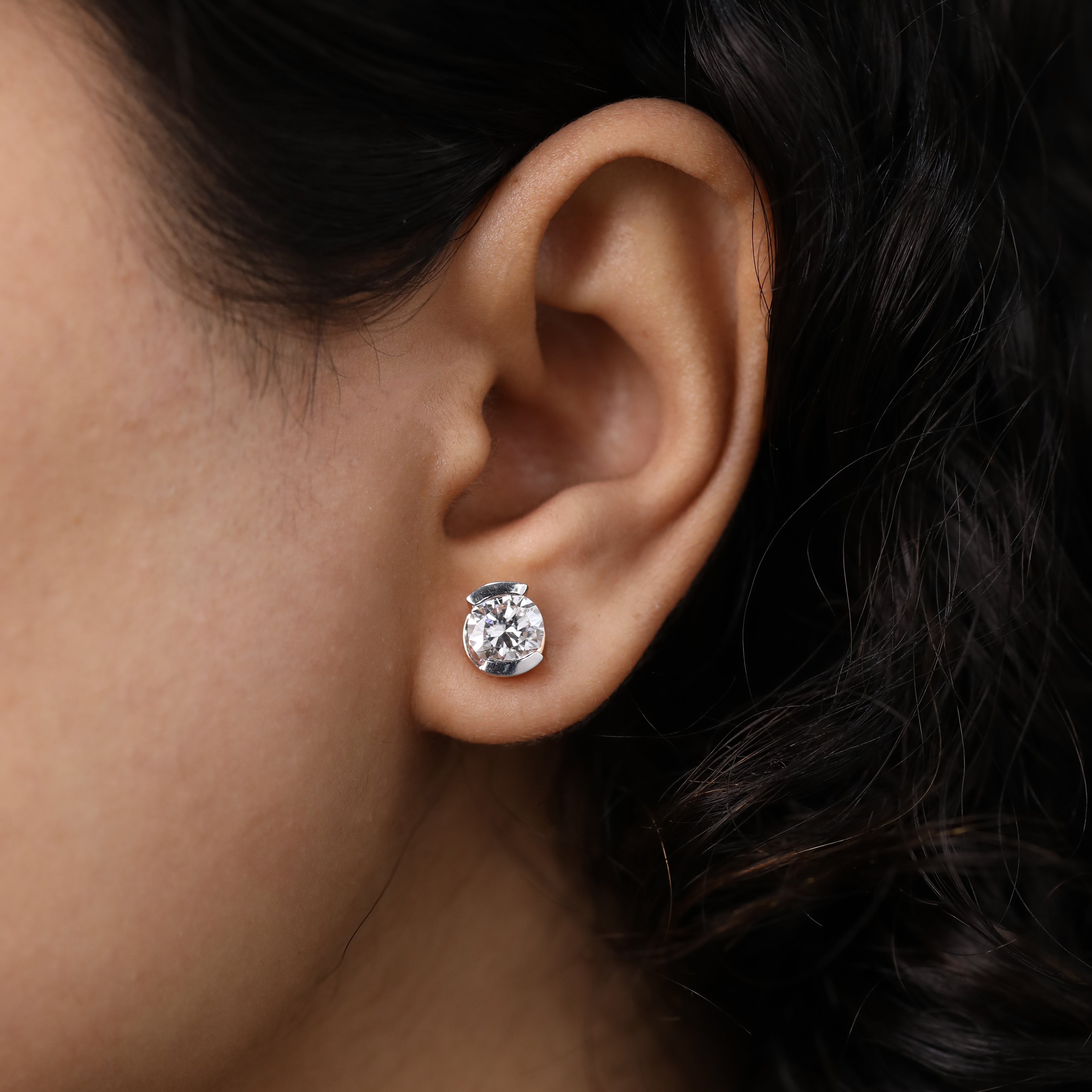 Sleek half-bezel round diamond studs suited for anniversary events.