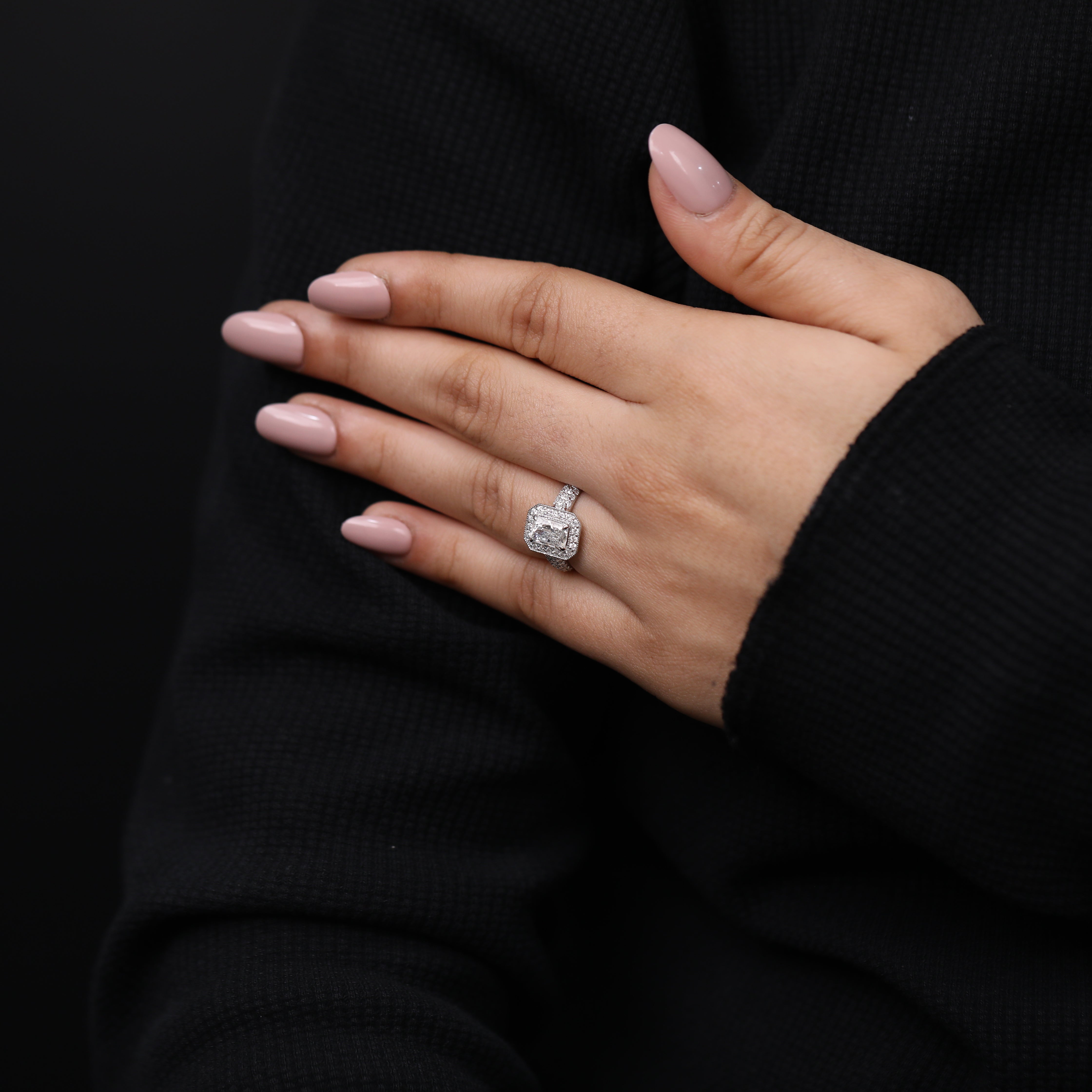 Luxury halo ring featuring an emerald cut lab diamond and accent stones.