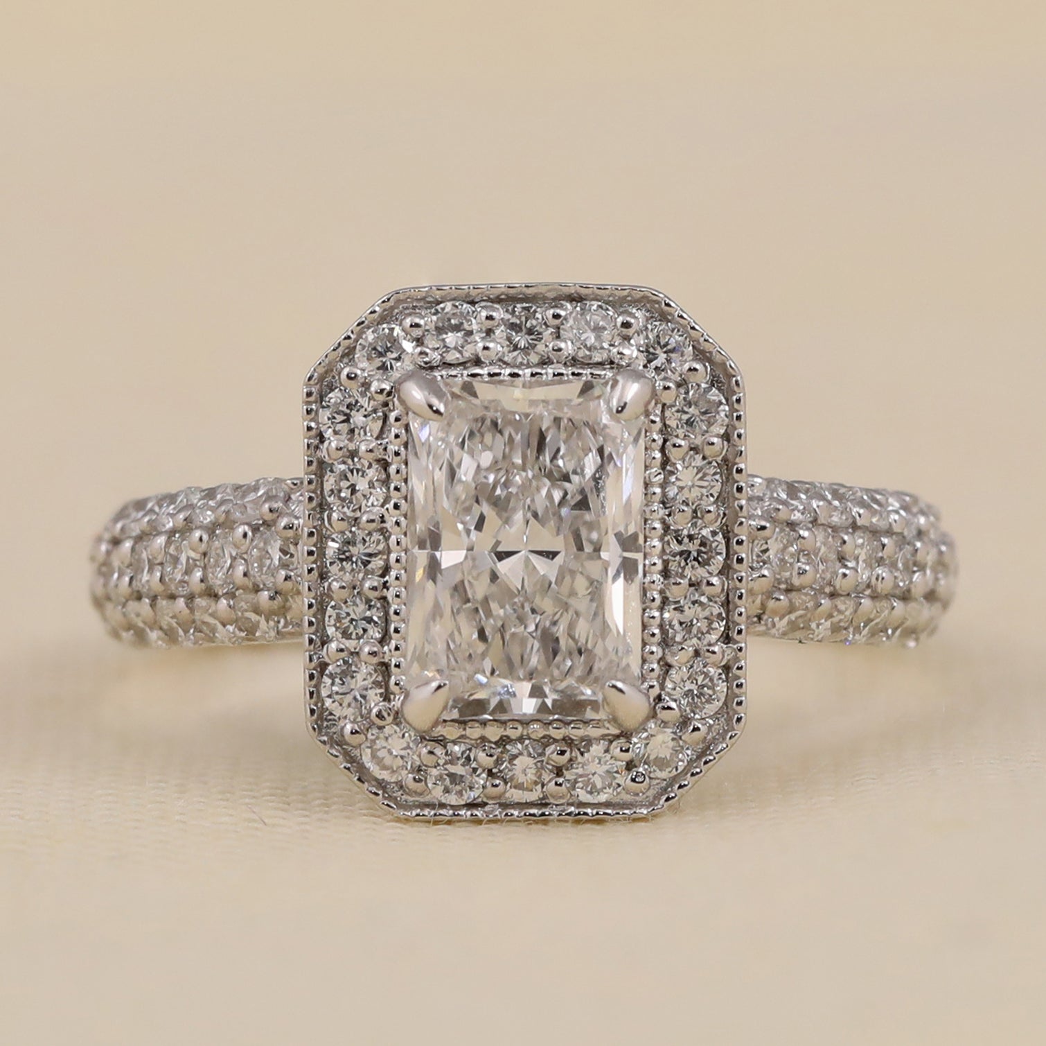 Emerald cut lab diamond halo engagement ring with pavé accents.