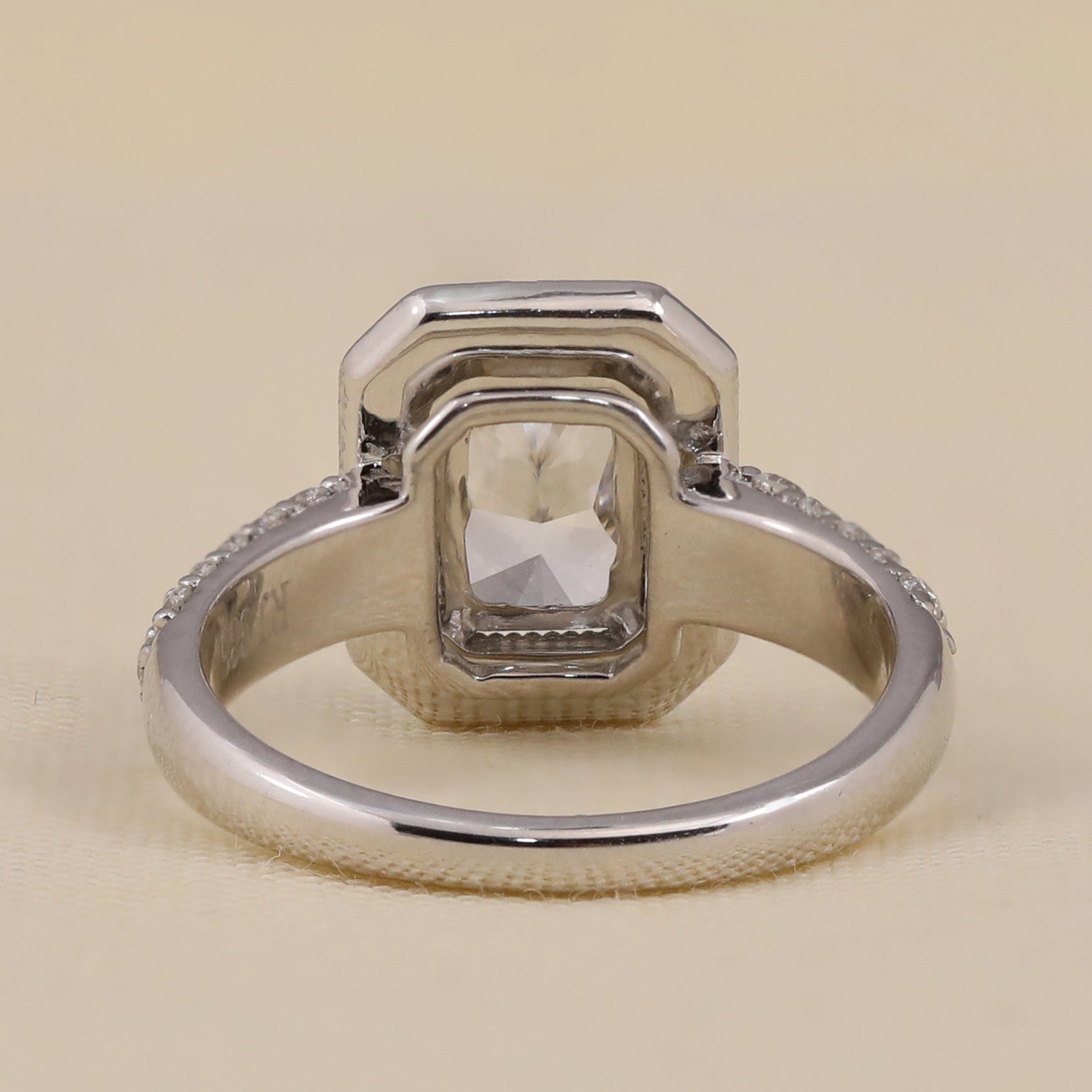 Emerald cut lab-grown diamond halo engagement ring for bridal wear.