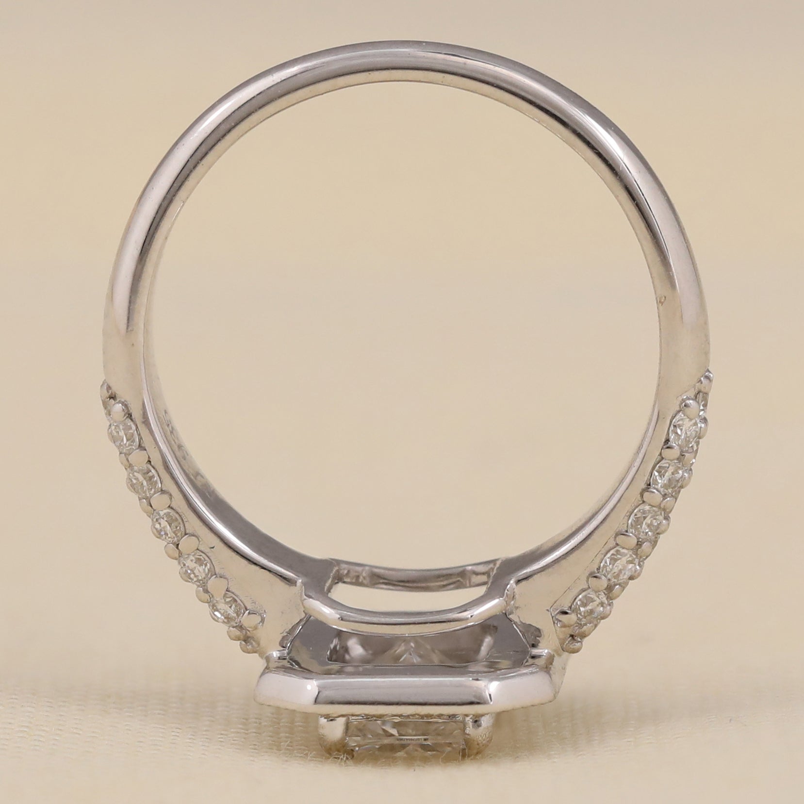 Elegant emerald cut lab diamond ring with halo and pavé detailing.