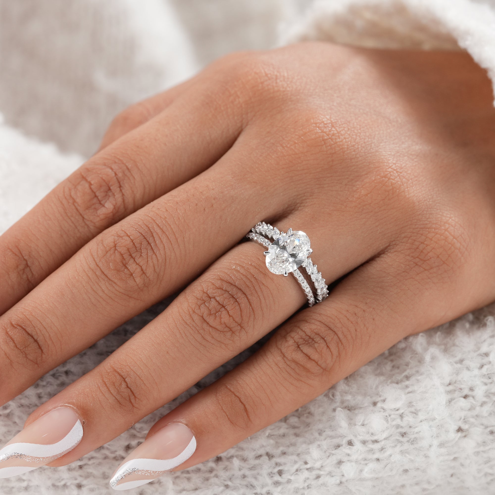 Oval solitaire engagement ring paired with marquise diamond eternity ring.