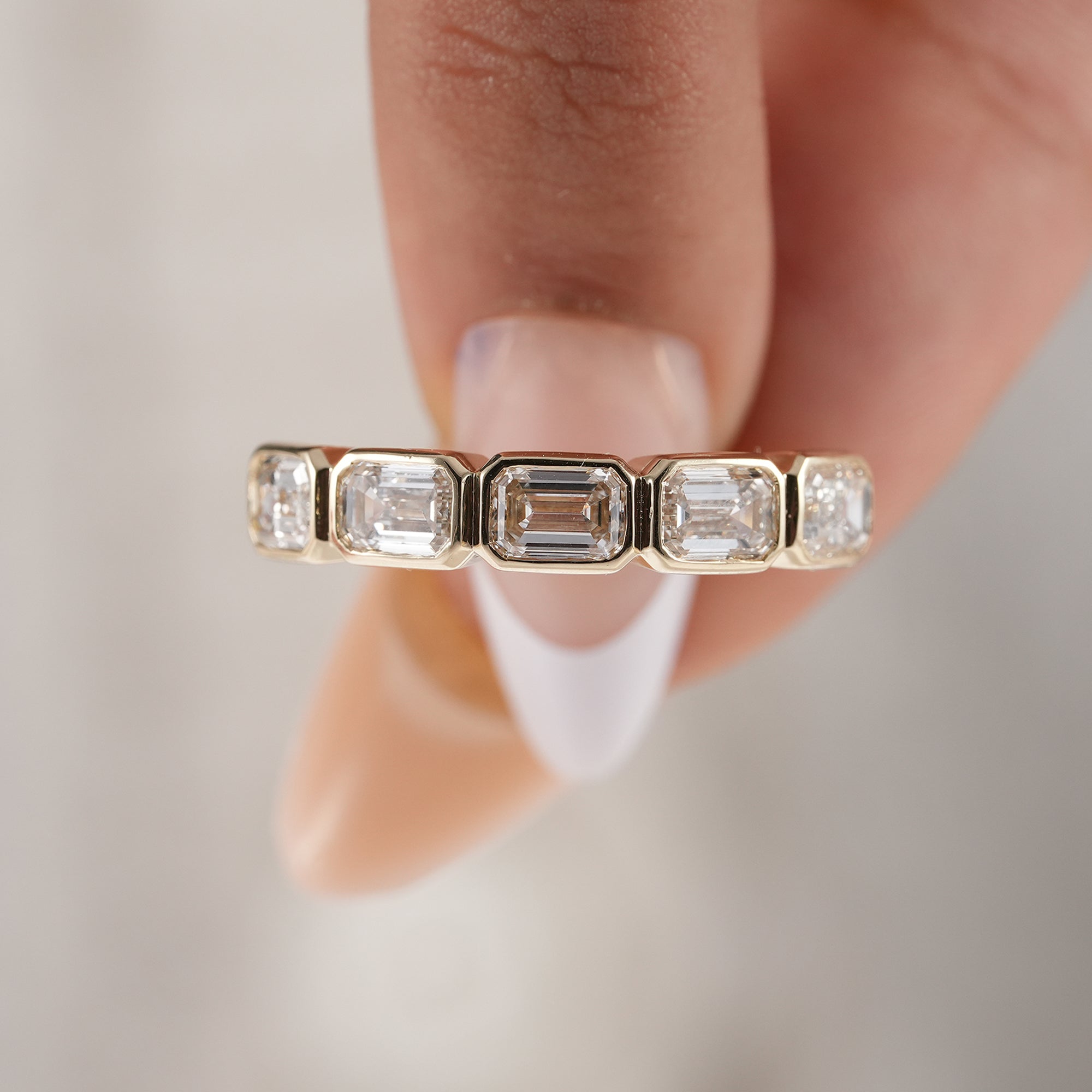 Luxury emerald eternity ring in solid yellow gold.