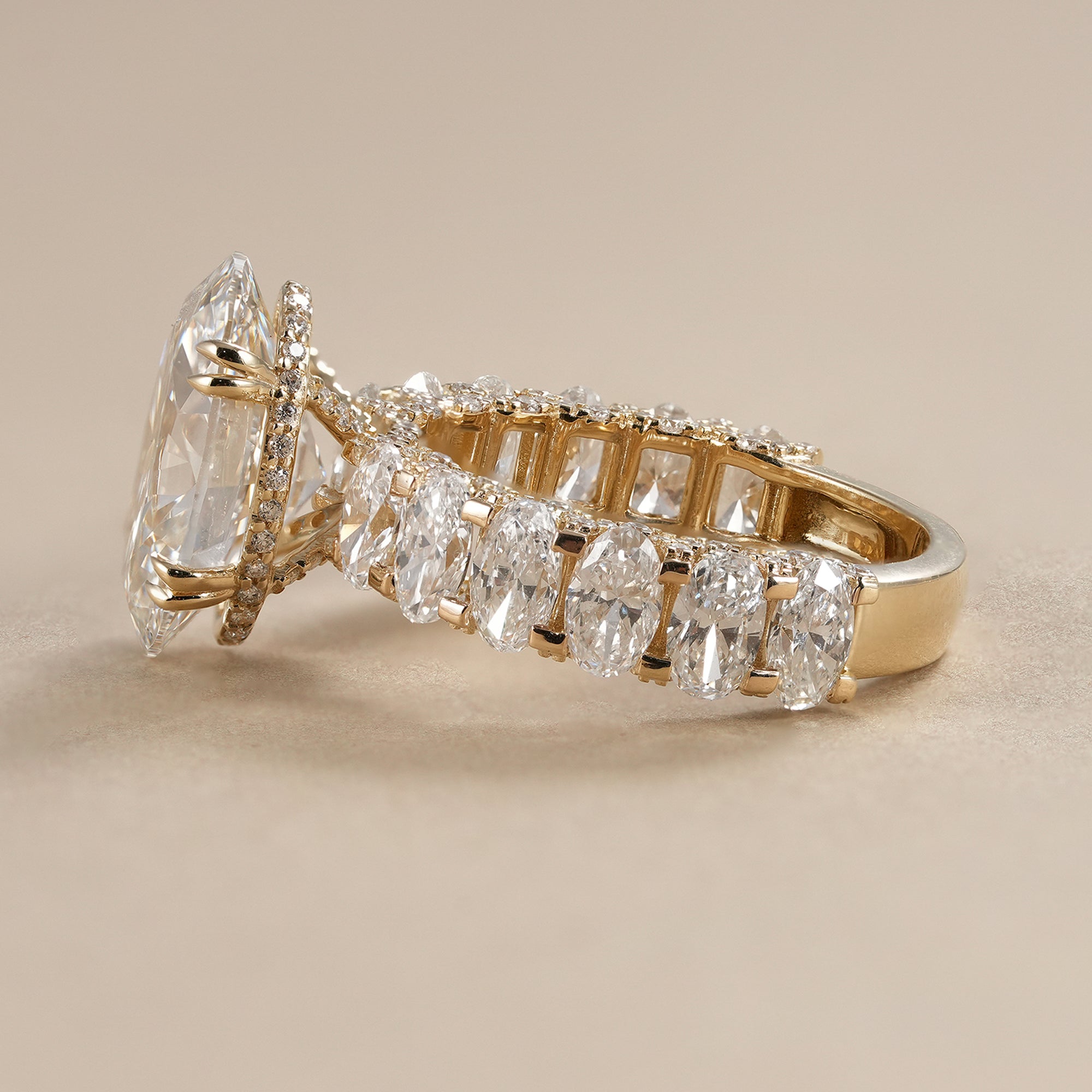 Elegant oval lab diamond engagement ring with hidden halo and sparkling oval side diamonds.