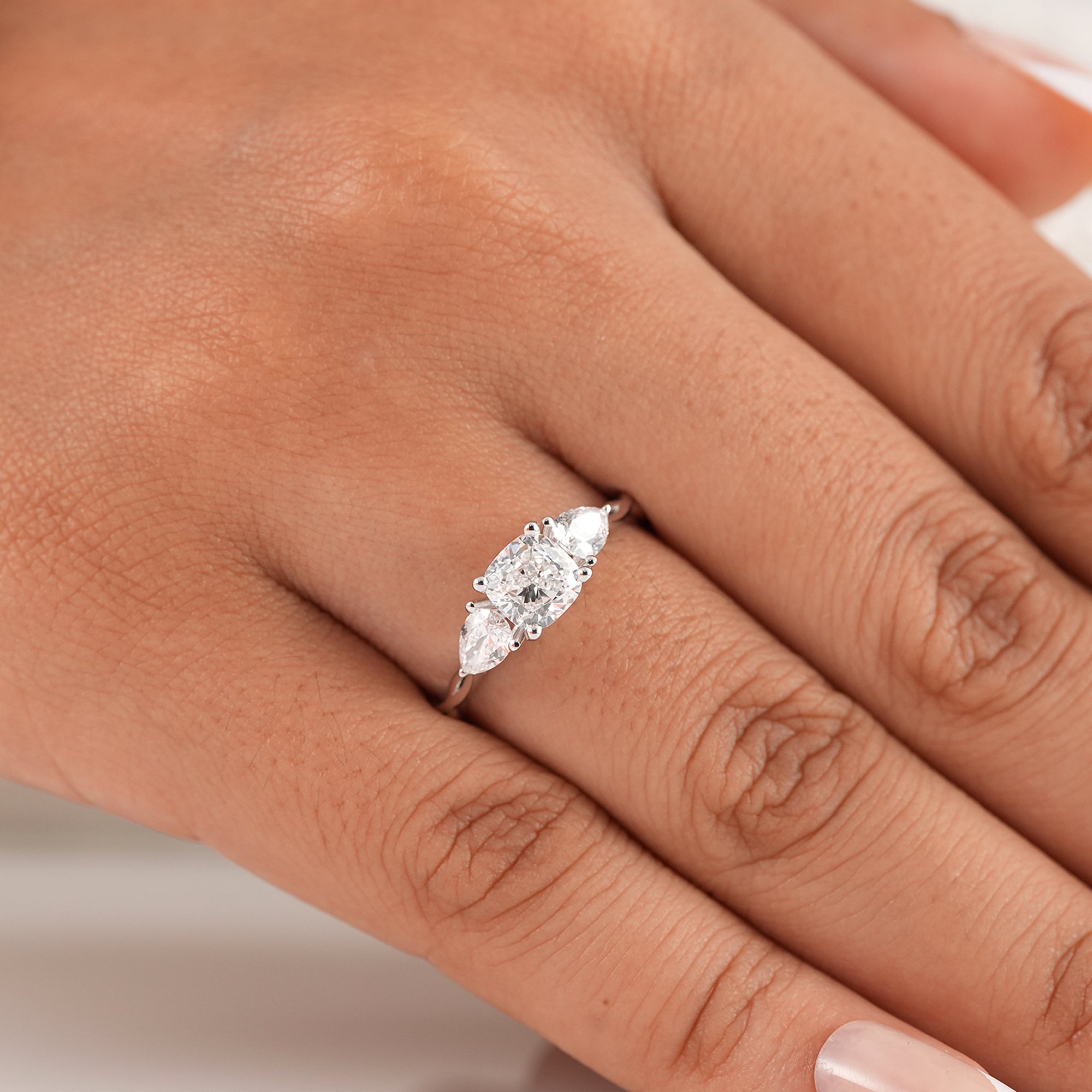 Cushion diamond anniversary ring with pear side stones