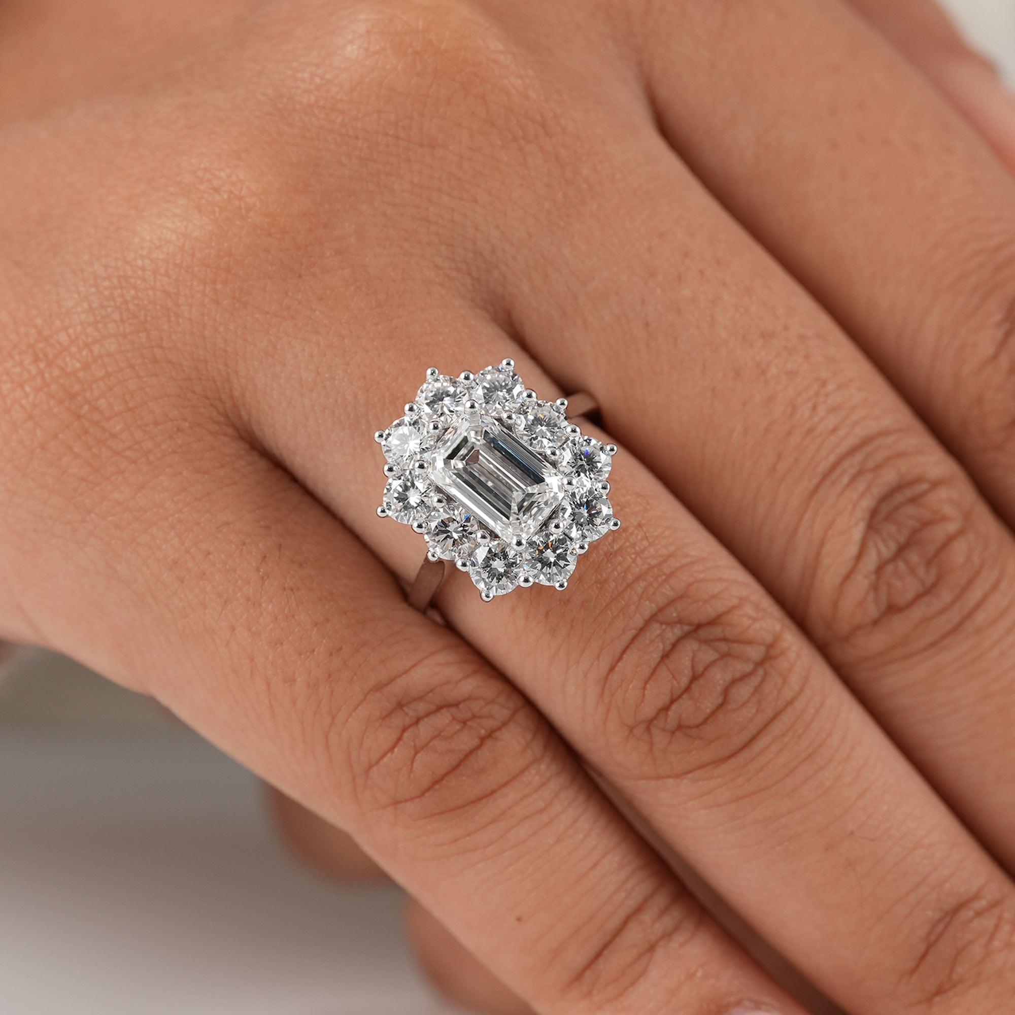 Luxury emerald cut diamond cocktail ring with round halo