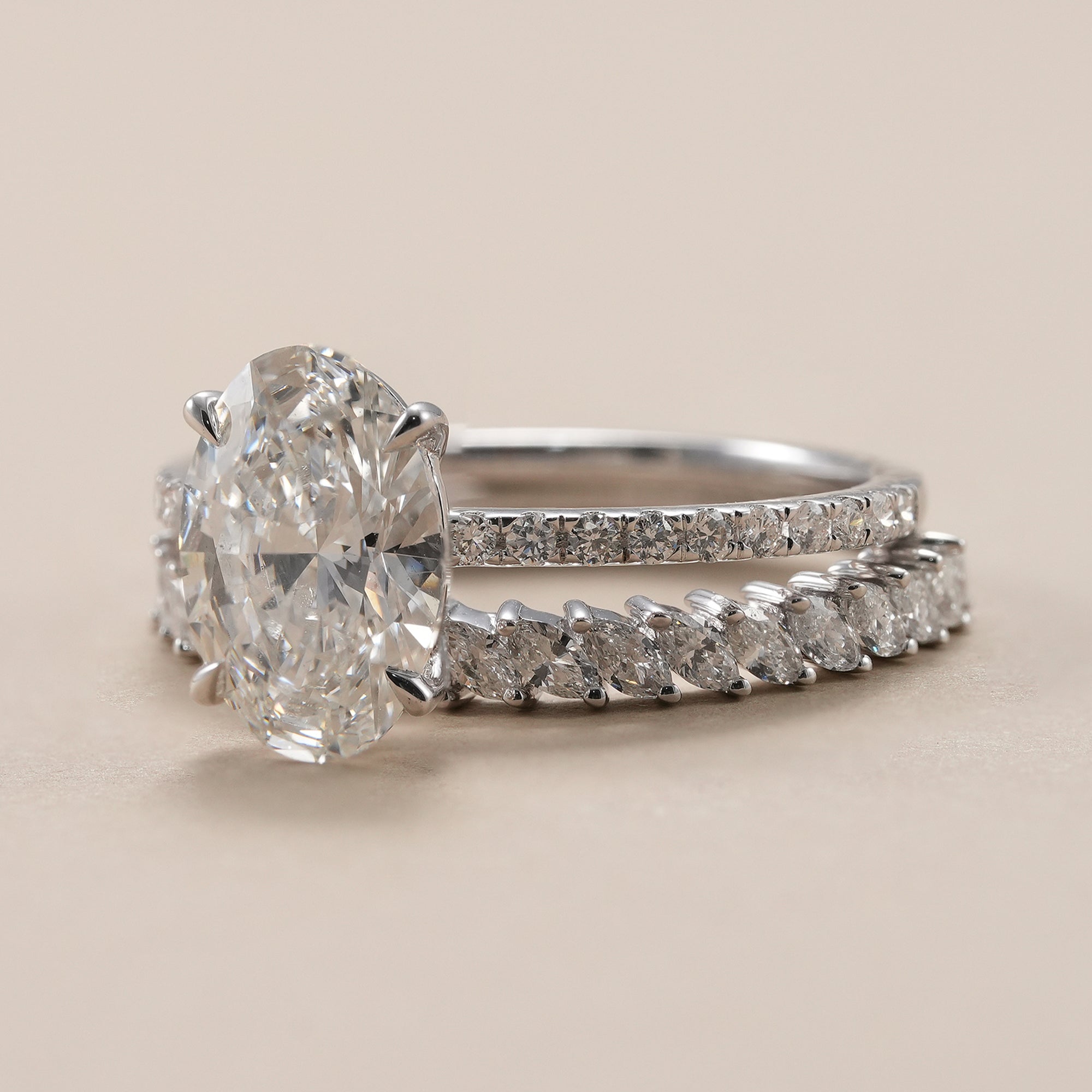 Oval solitaire lab diamond engagement ring with marquise eternity band.