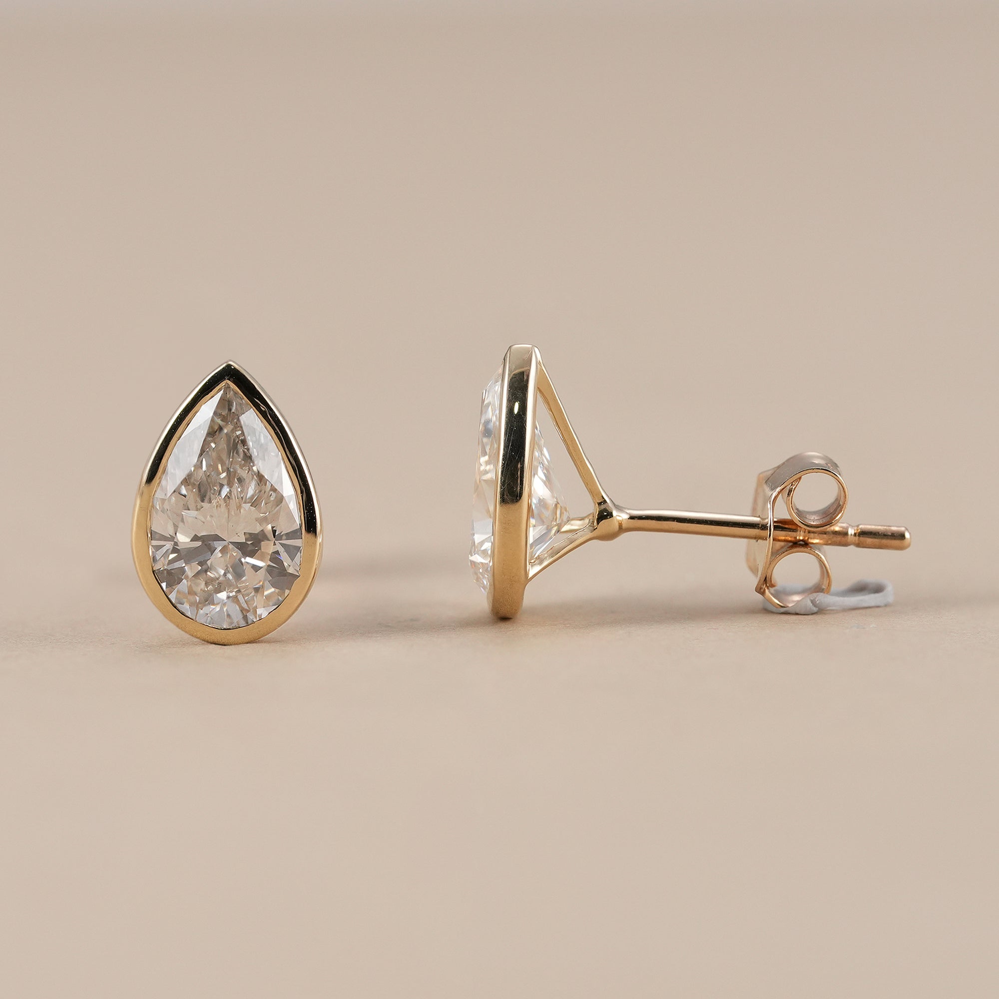 IGI certified pear bezel solitaire diamond stud earrings