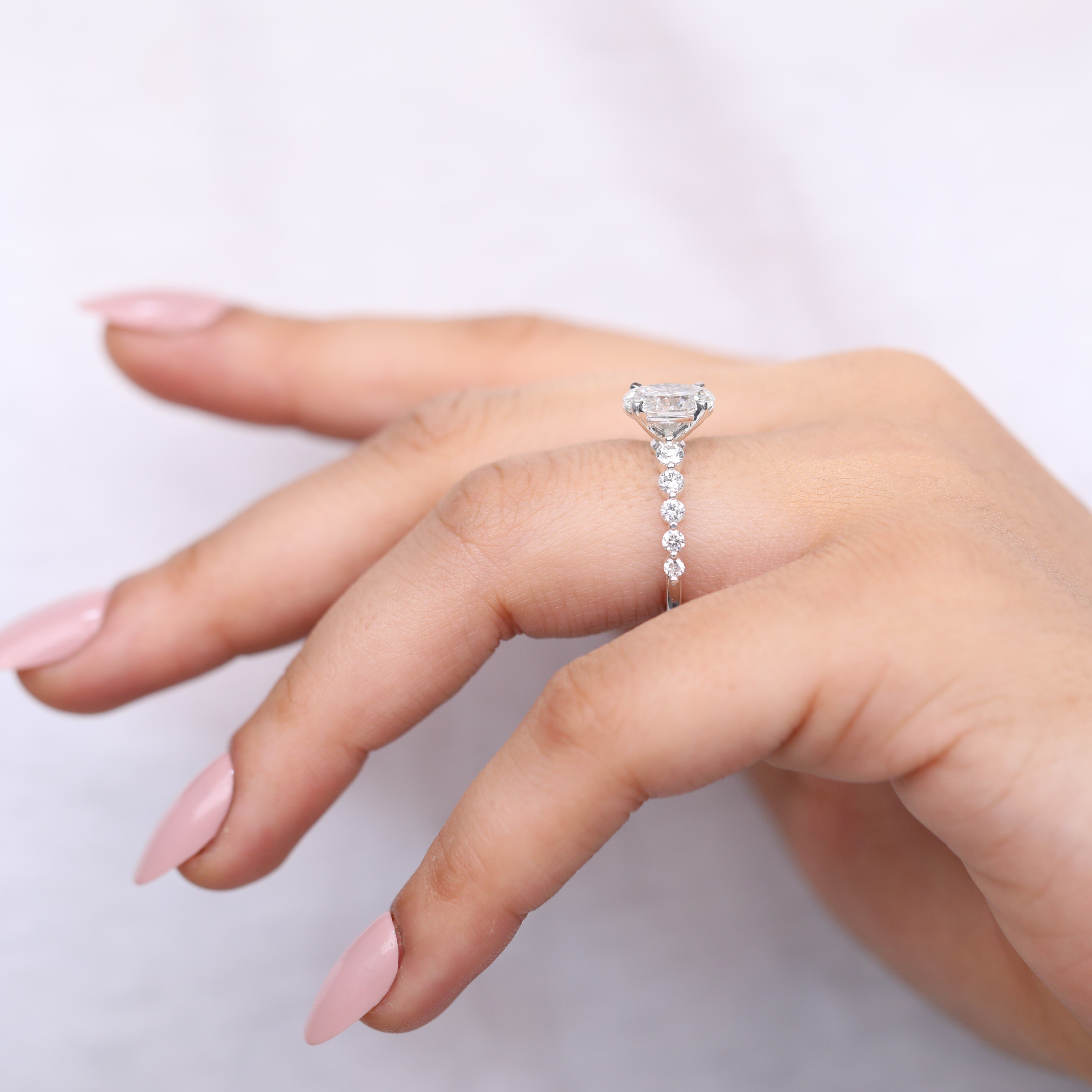 Fine jewelry oval lab-grown diamond ring in a side-stone engagement design