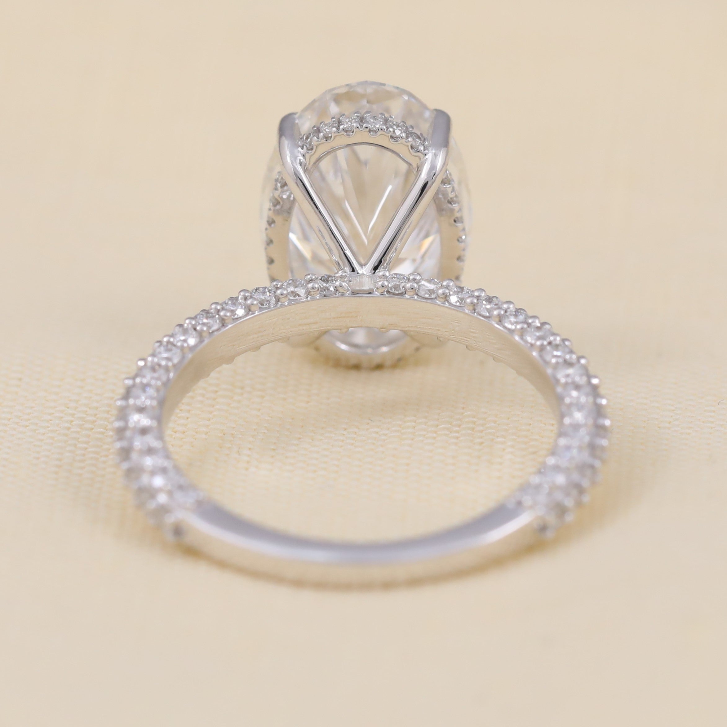 Oval lab grown diamond solitaire enhanced by subtle pavé side stones
