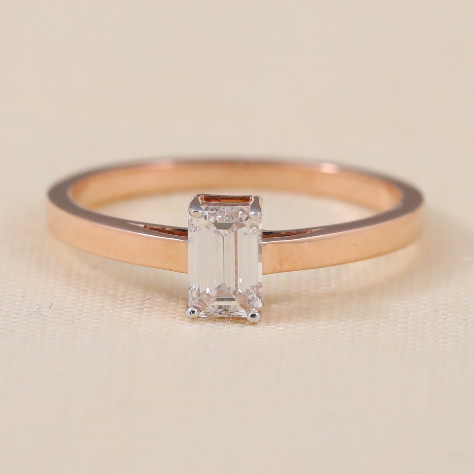 Emerald cut lab grown diamond solitaire ring featuring a clean minimalist band