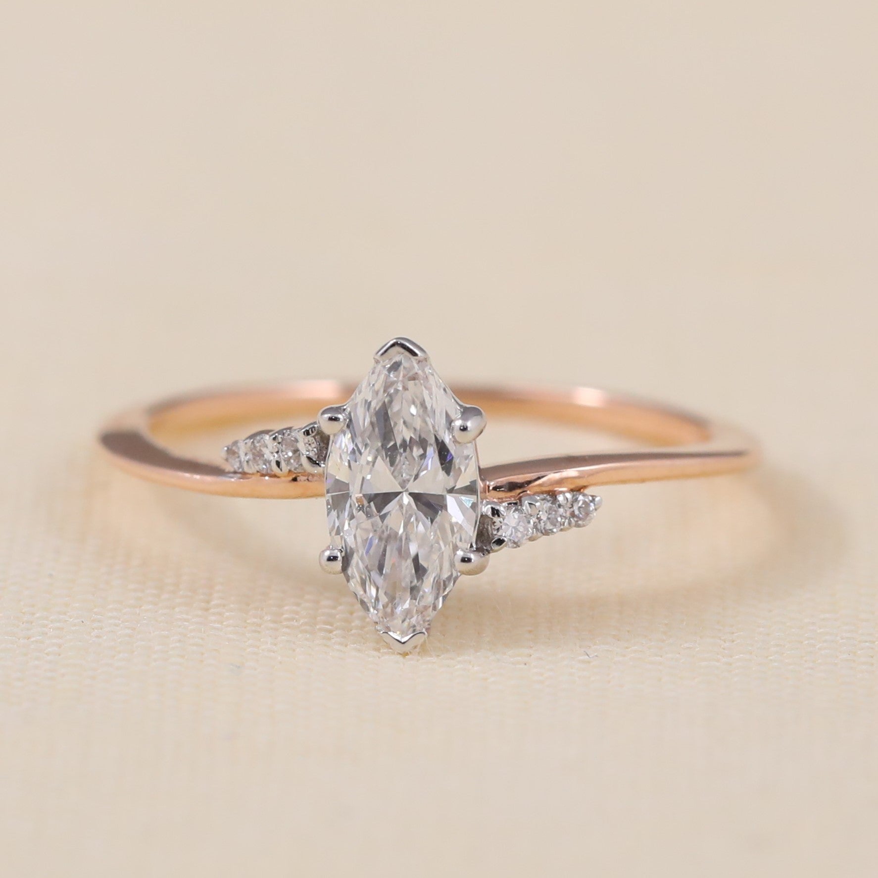 Marquise cut lab grown diamond ring featuring elegant side stones and slim band
