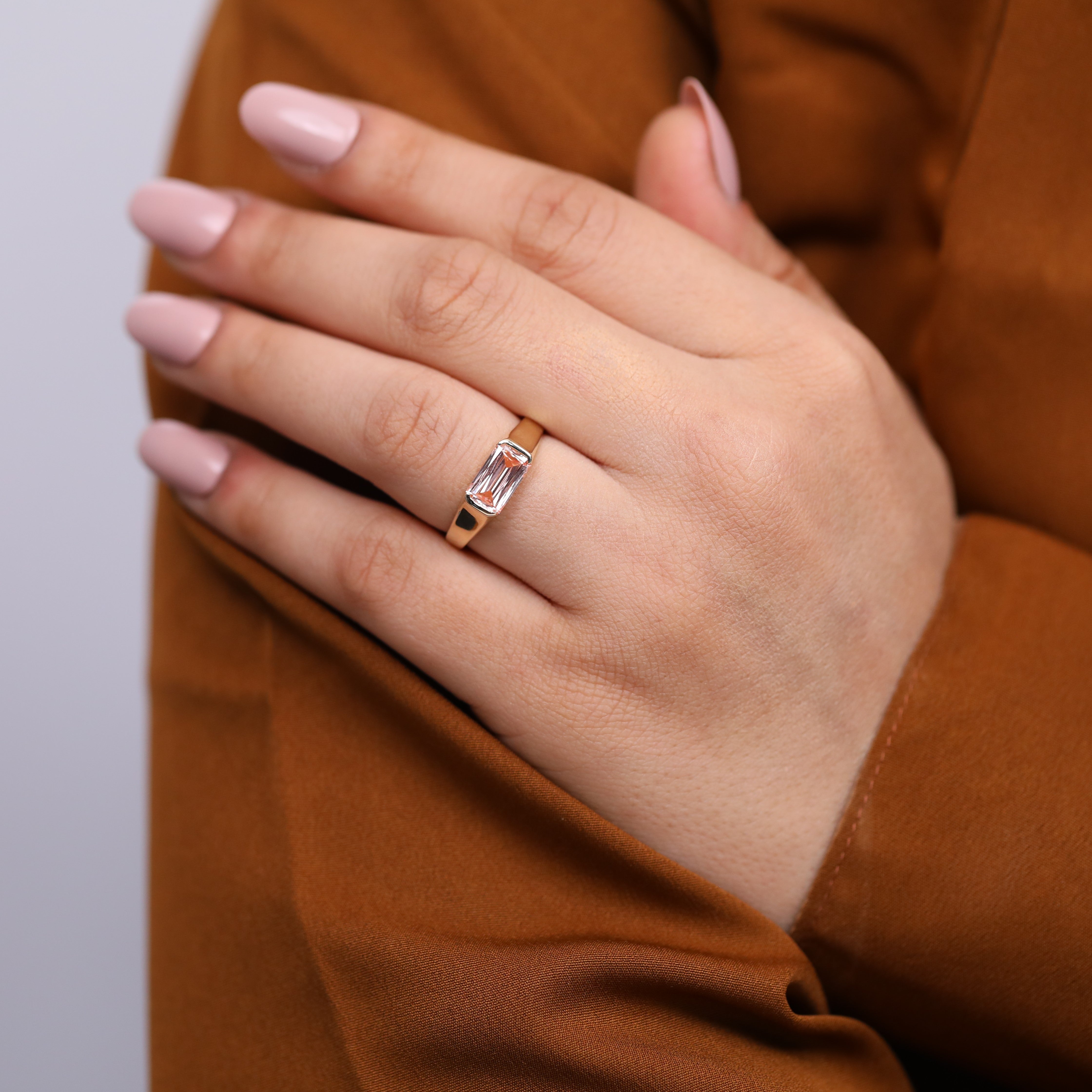 Minimalist gold bezel ring with pink lab grown emerald cut diamond.
