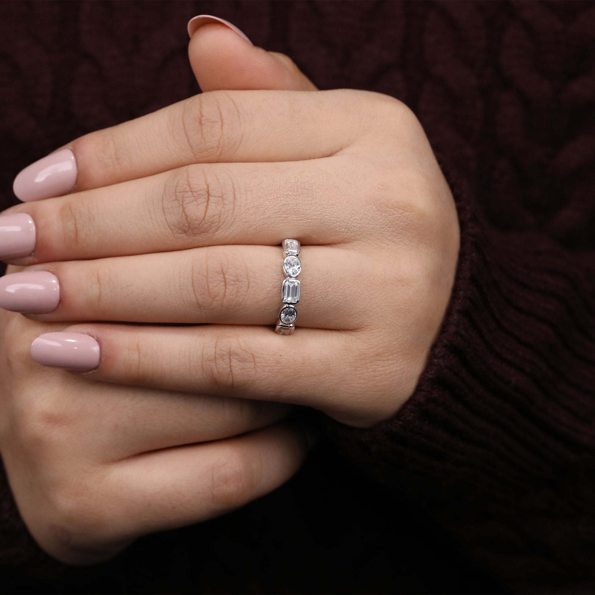 Modern lab diamond ring with emerald cut center stone framed by oval and round diamonds