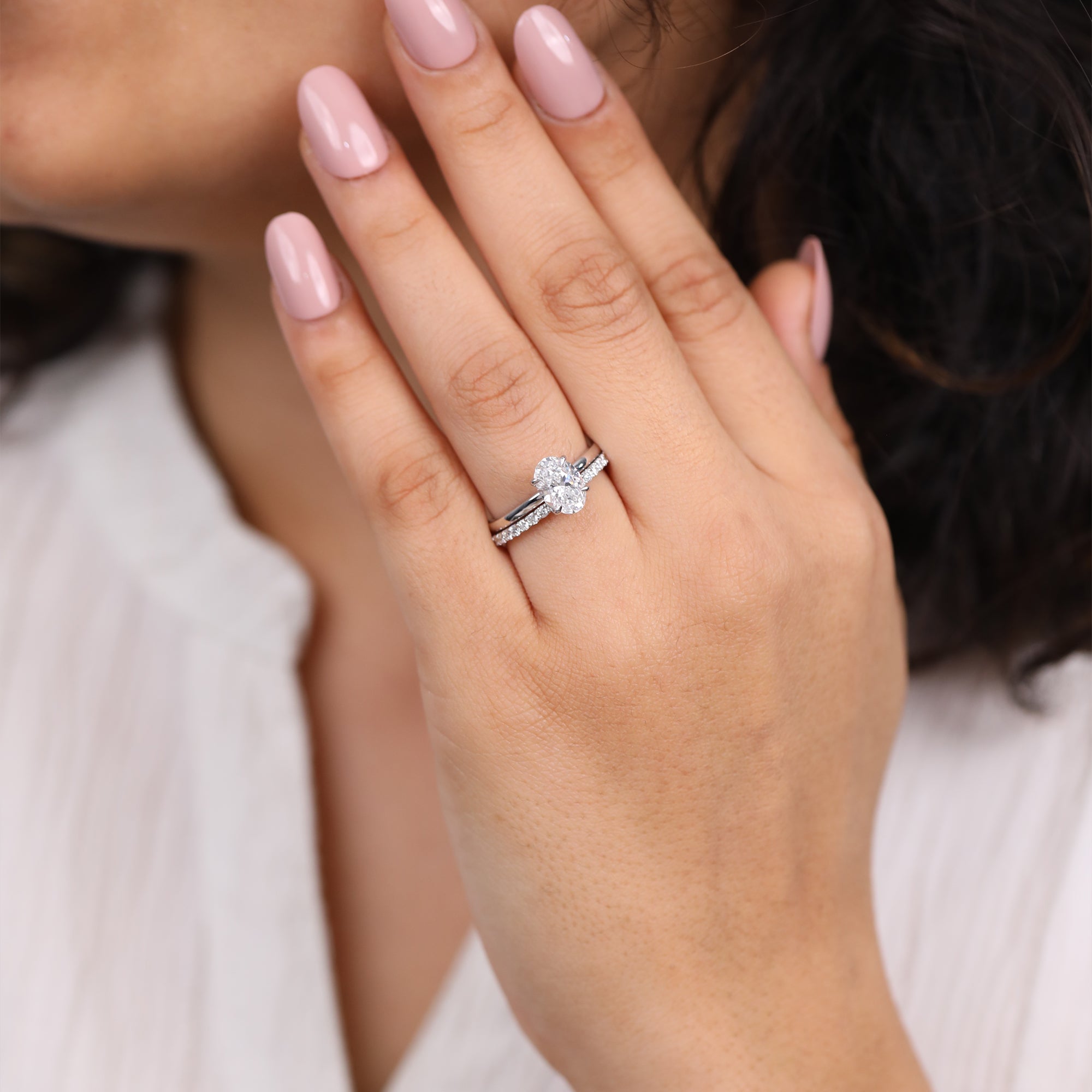 Classic oval diamond engagement ring paired with a delicate pavé wedding band