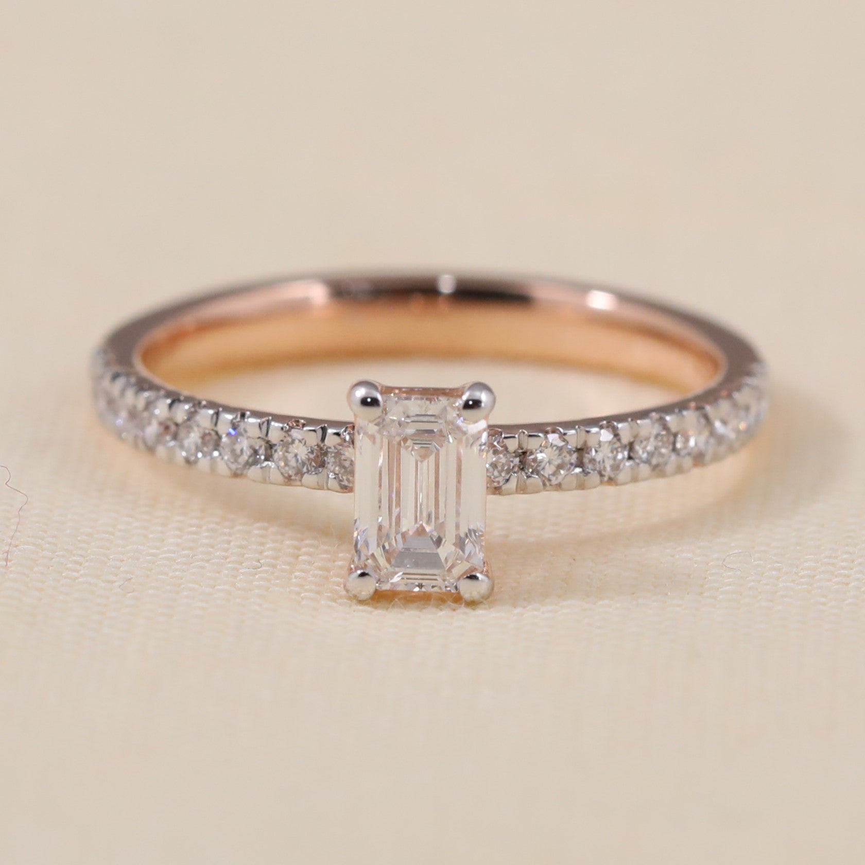 Emerald cut lab grown diamond ring featuring a sparkling pavé rose gold band