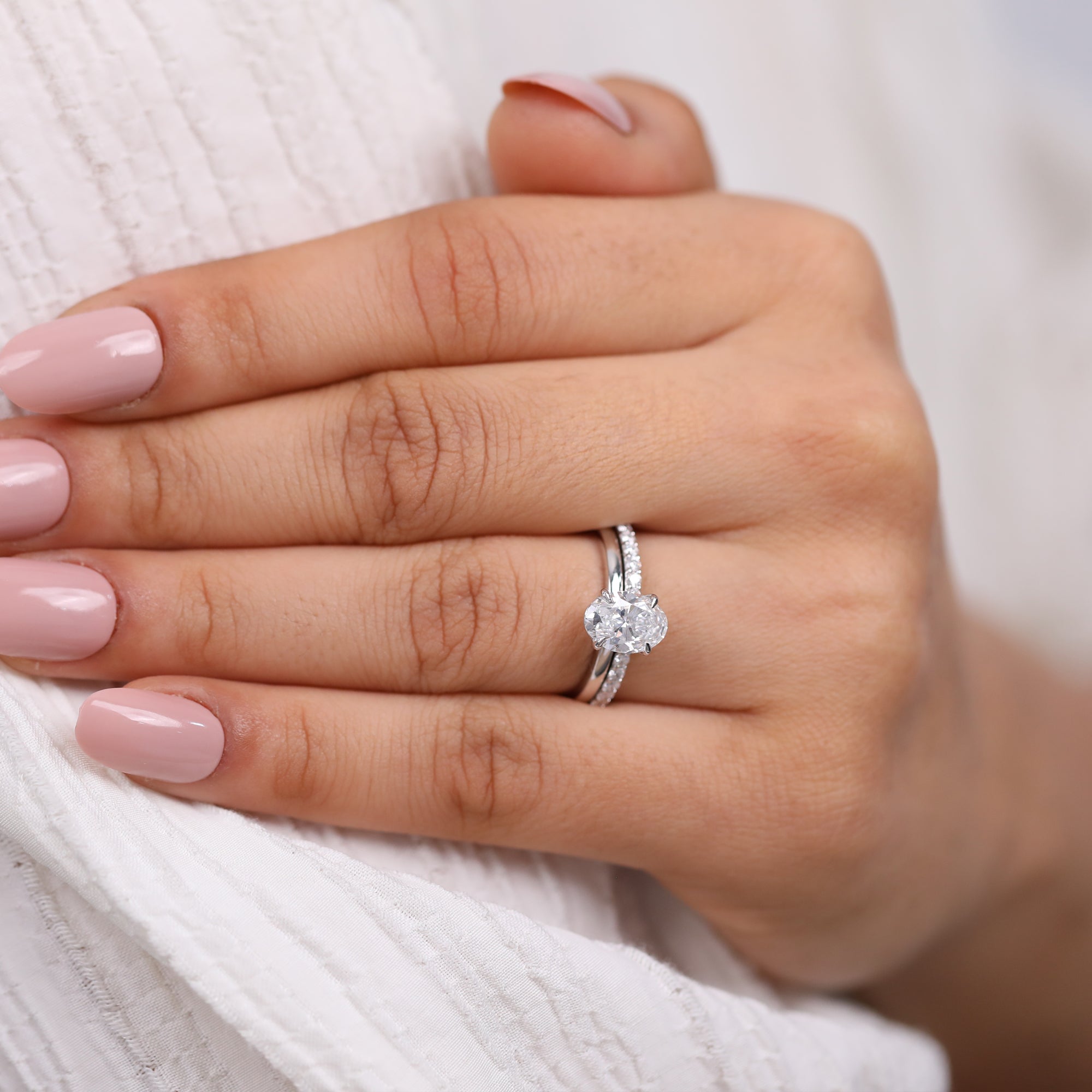 Fine jewelry bridal set with oval solitaire and pavé diamond matching band