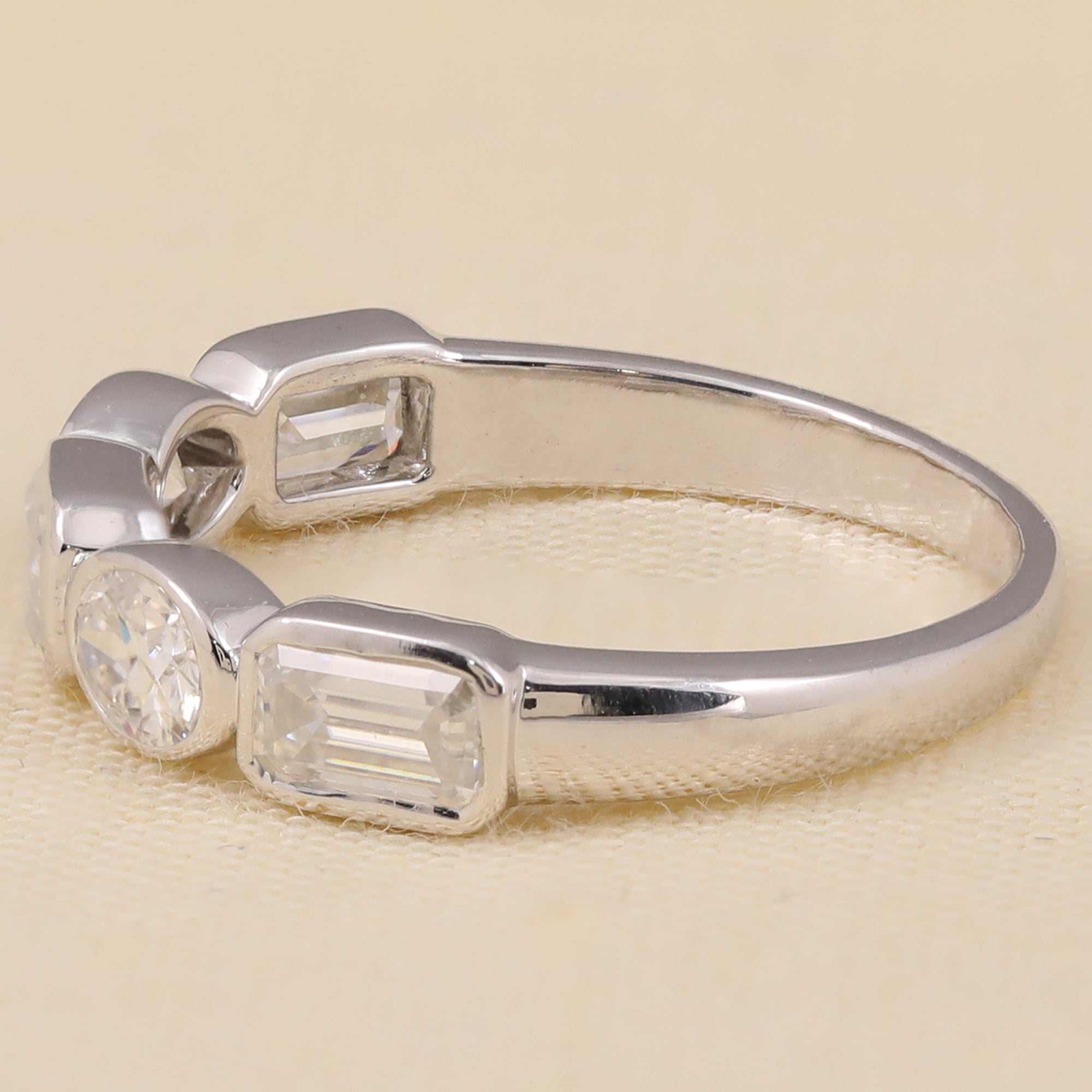 Elegant lab-grown diamond ring showcasing a center emerald-cut diamond with oval and round side stones