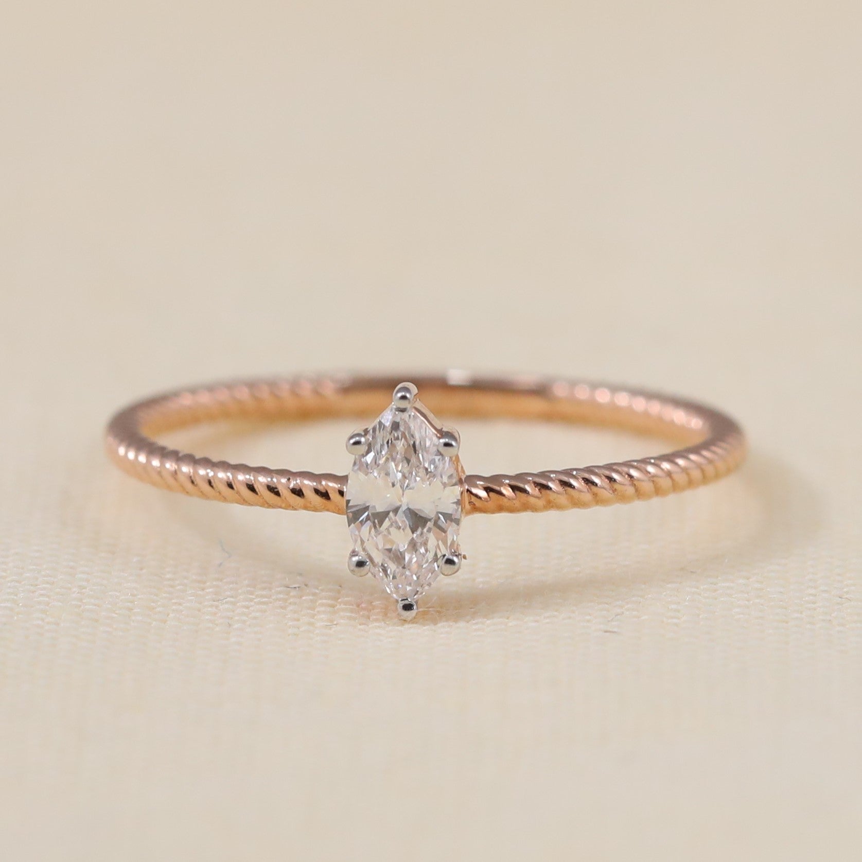 Marquise cut lab grown diamond engagement ring featuring a delicate twisted band