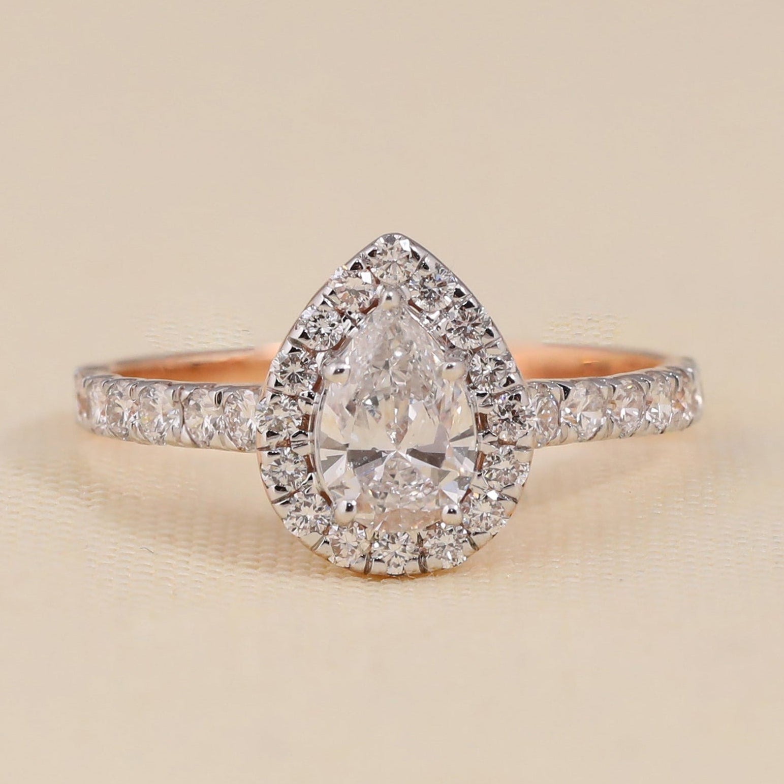 Pear cut lab grown diamond halo engagement ring with pavé band