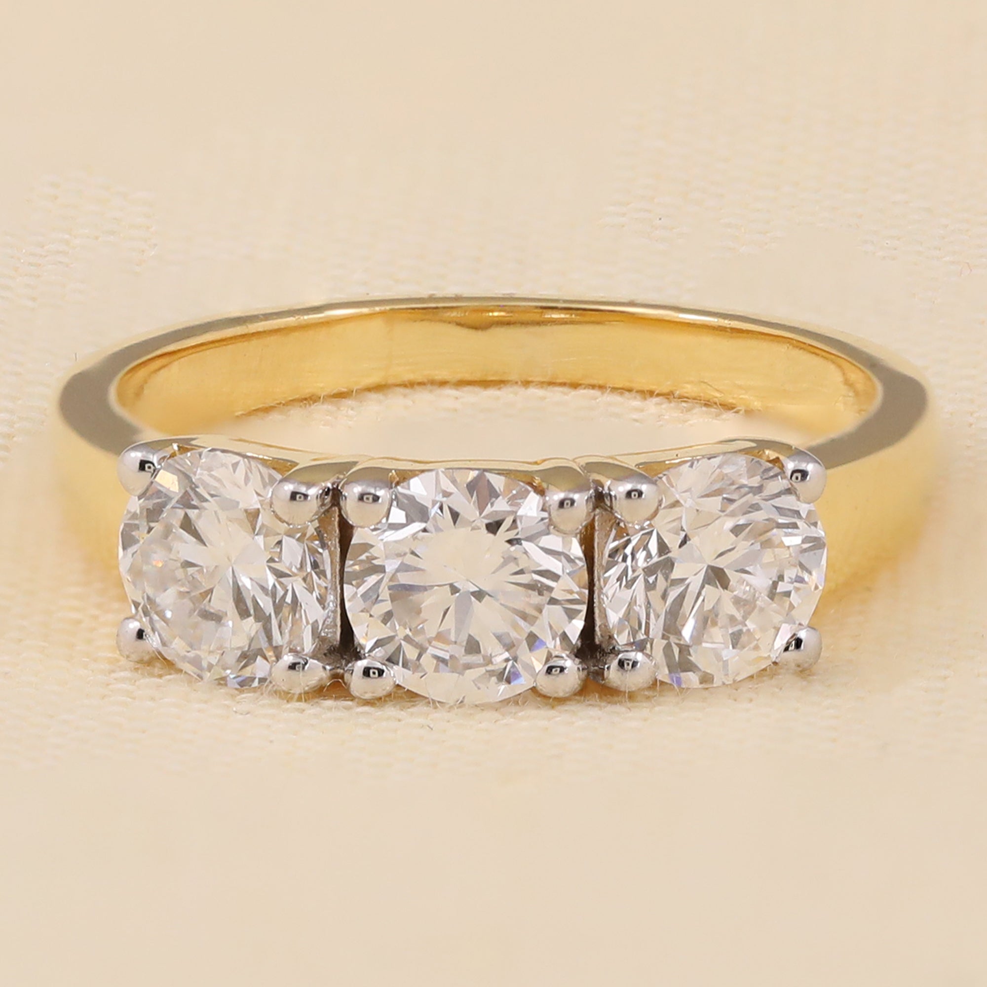 Three-stone lab diamond ring featuring brilliant round-cut stones in a sleek modern design