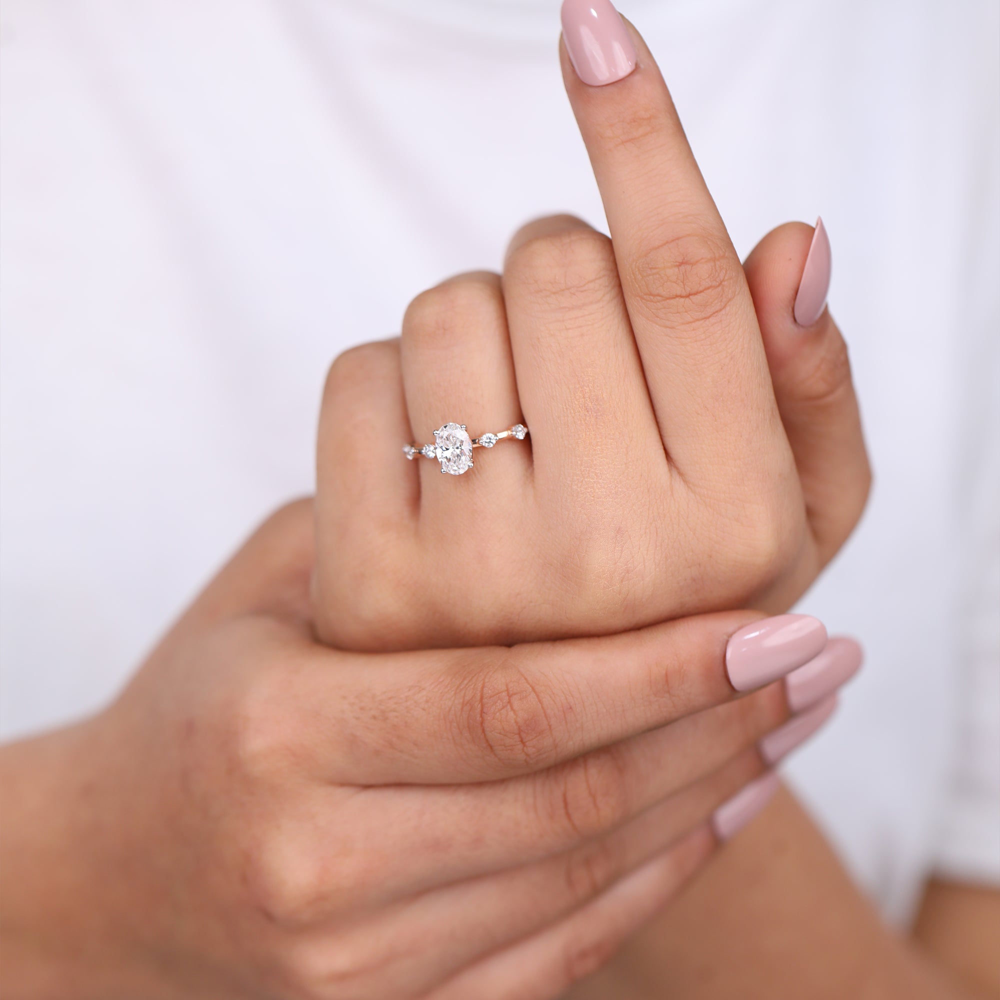 Rose gold oval-cut lab-grown diamond engagement ring with round side stones