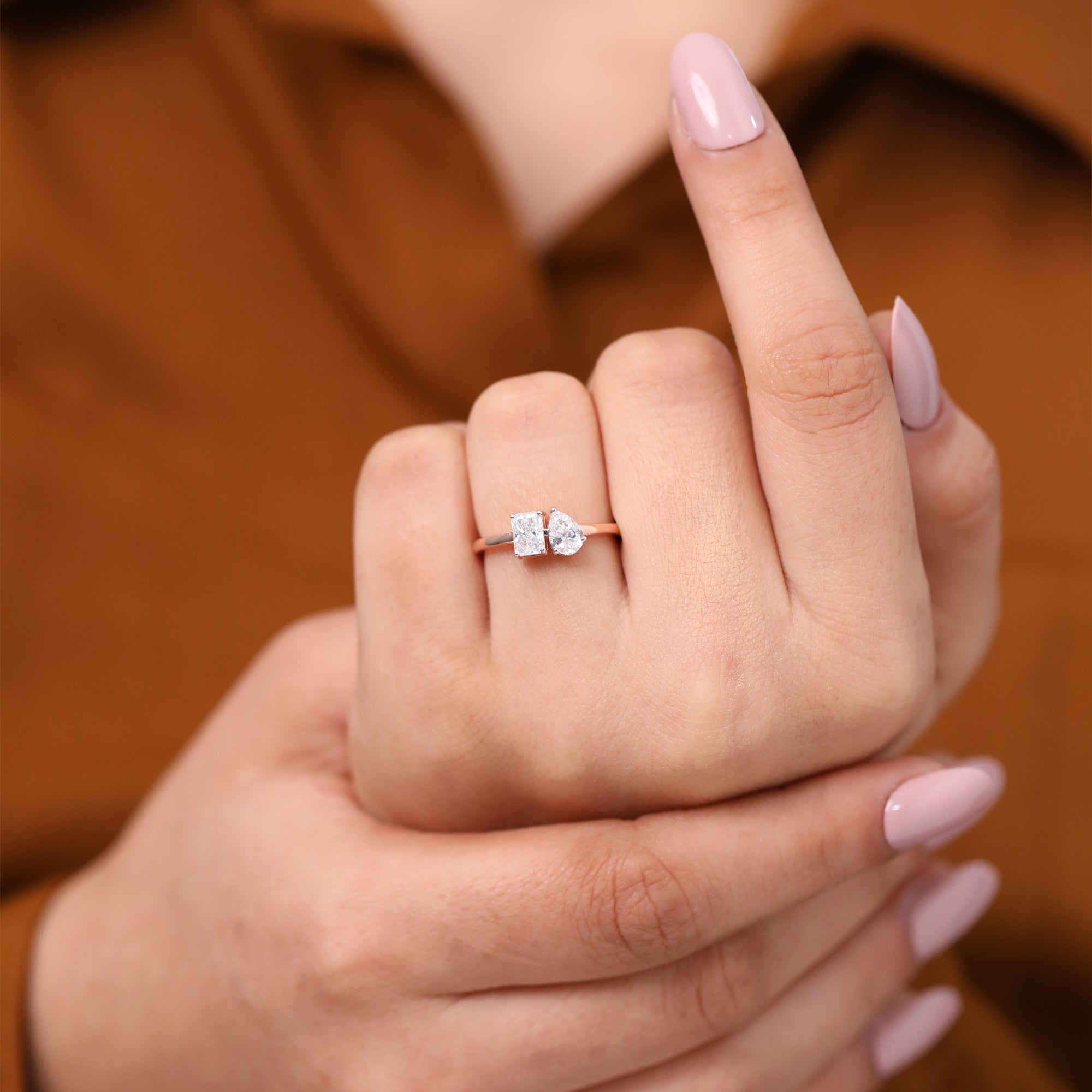 Stylish engagement ring featuring radiant cut and pear cut lab grown diamond toi et moi ring